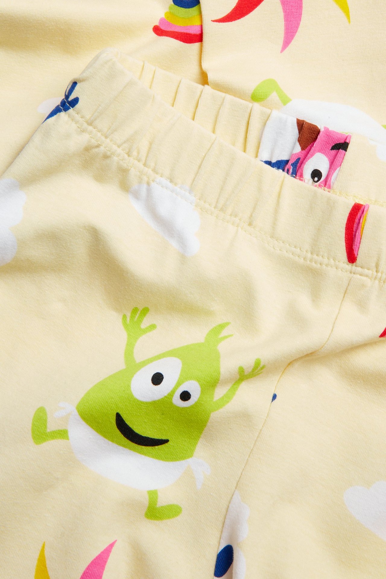 Lähikuva vaaleanbeigen vauvan leggingseistä, joissa resori vyötäröllä ja värikäs Babblarna-kuvio.