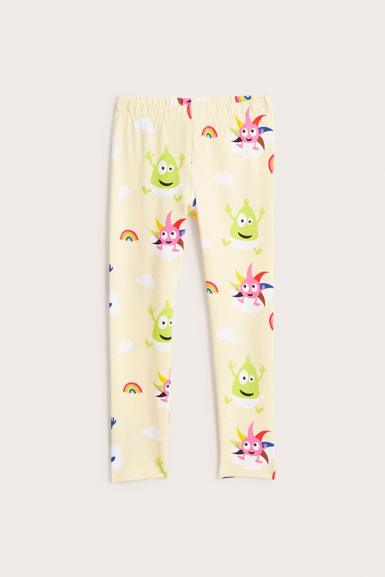 Widok z przodu: jasnobeżowe legginsy niemowlęce z kolorowymi postaciami Babblarna i tęczami.