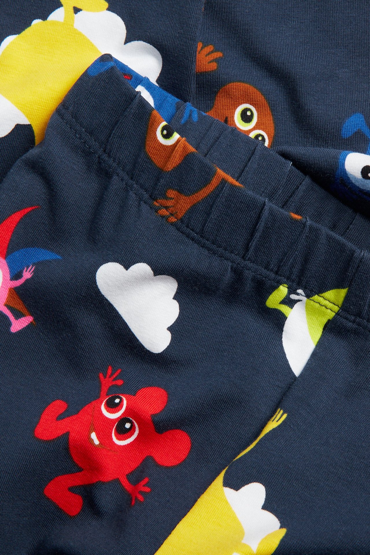 Lähikuva kuviollisista tummansinisistä vauvaleggings-housuista, joissa Babblarna-kuvio ja joustava vyötärö.