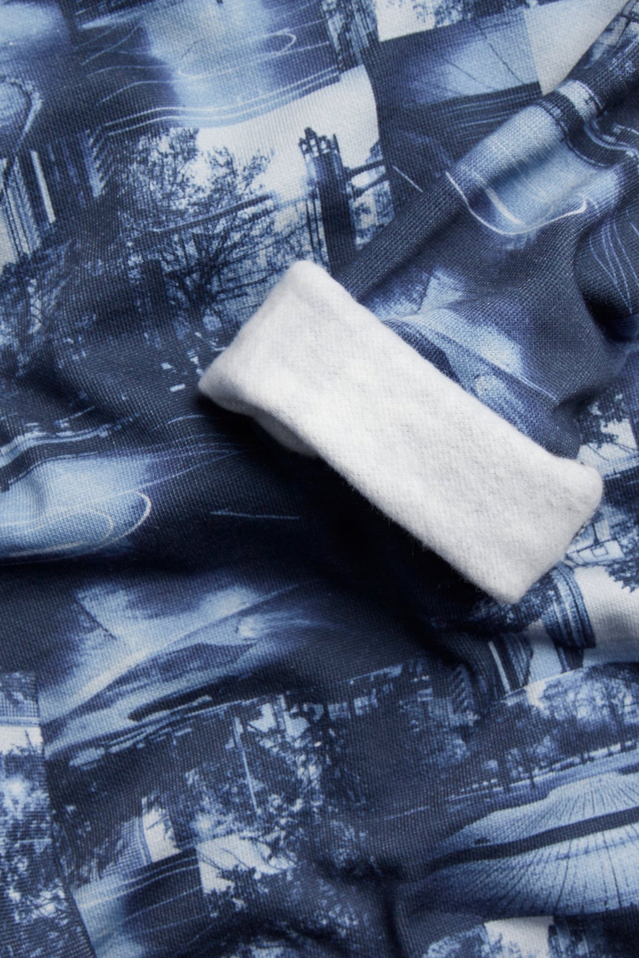 Lähikuva sinisestä kuviollisesta puuvillapaidasta, jossa on valkoinen ranneke.
