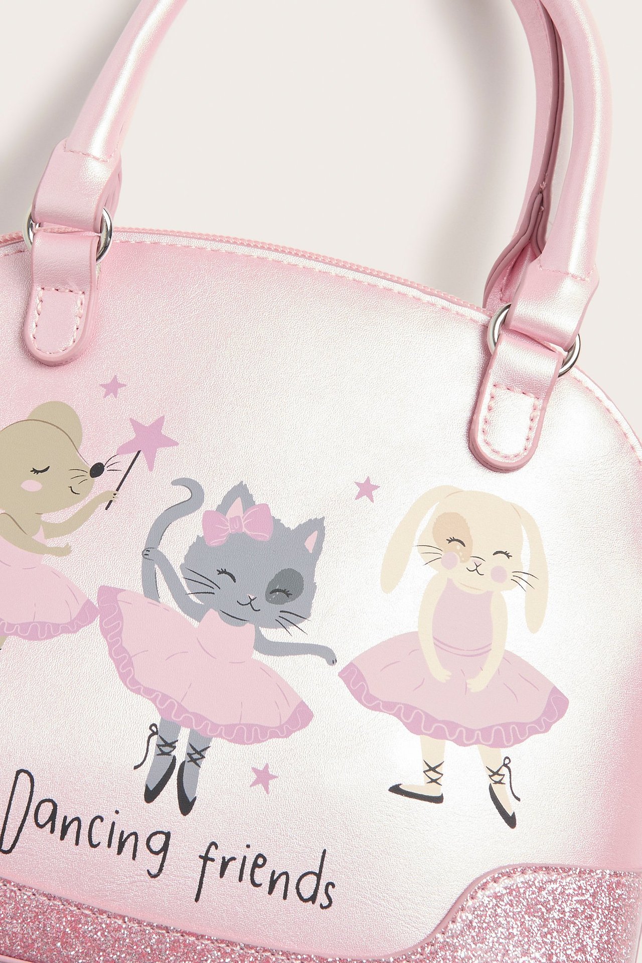 Zbliżenie z przodu jasnoróżowej torebki z dwoma uchwytami, z nadrukiem tańczących zwierząt i brokatowym detalem.