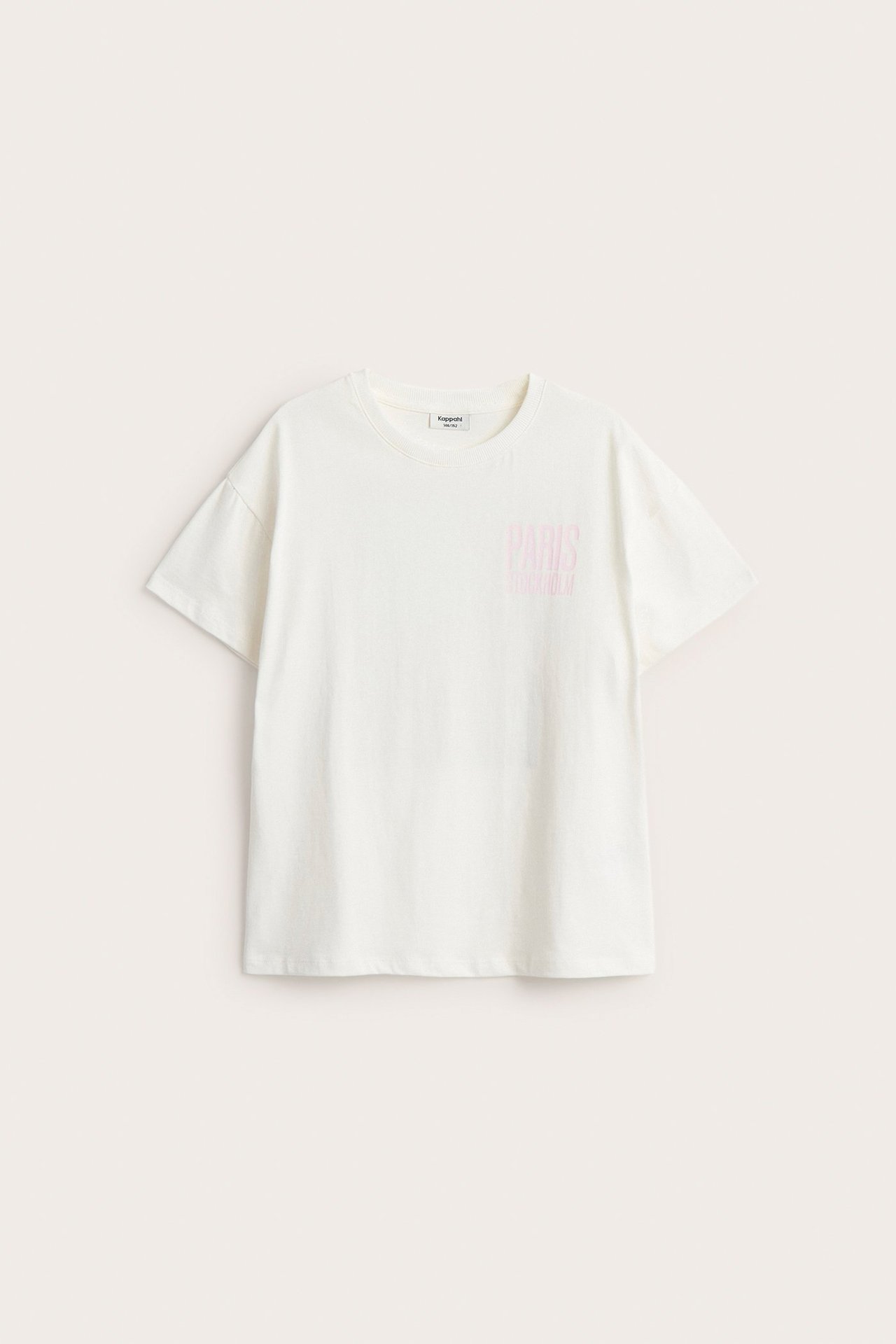 Framifrån: Benvit bomulls-t-shirt med korta ärmar och ljusrosa 'PARIS'-tryck på bröstet.