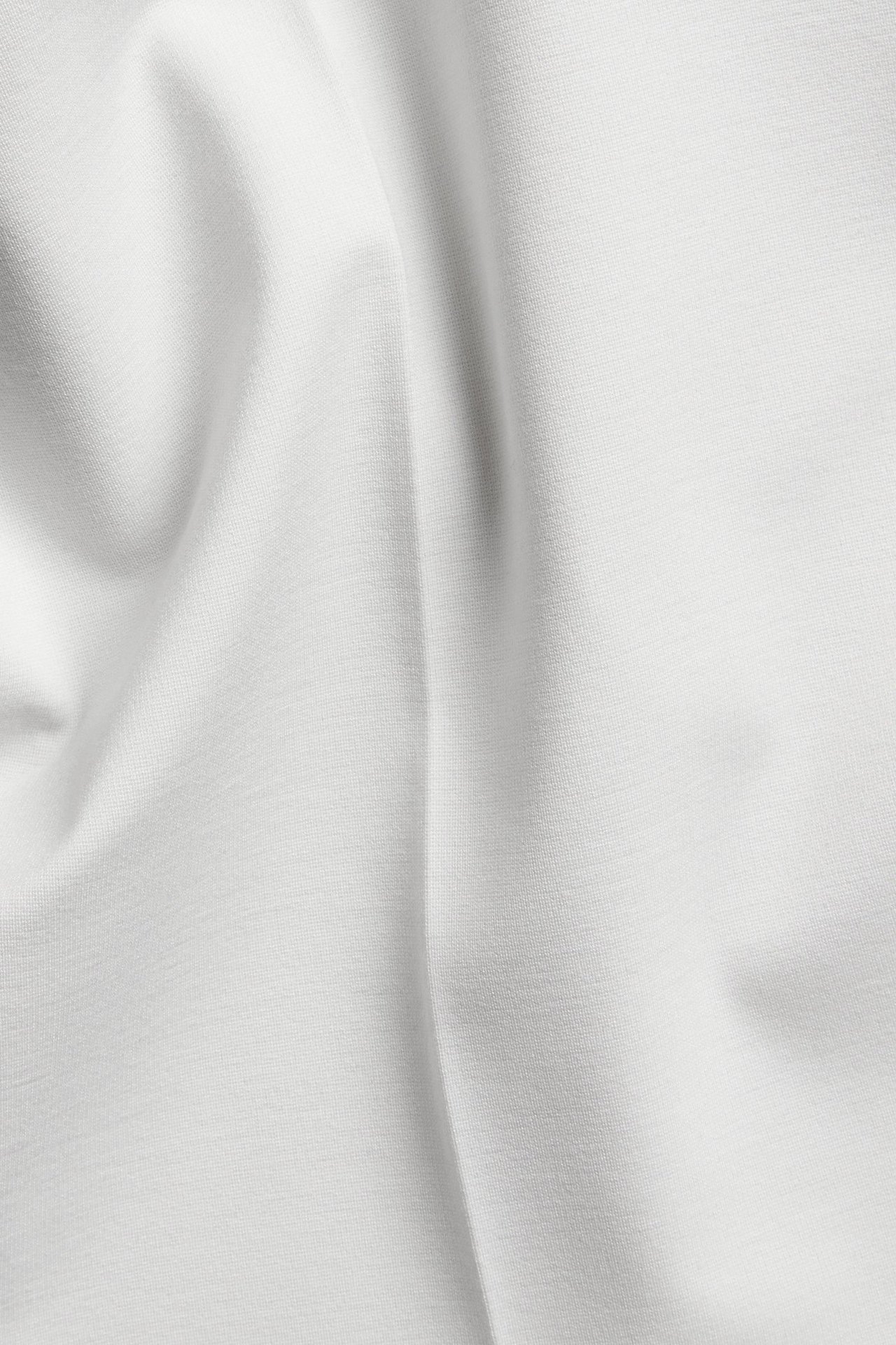 Zbliżenie na białą tkaninę Punto Jersey spodni garniturowych.