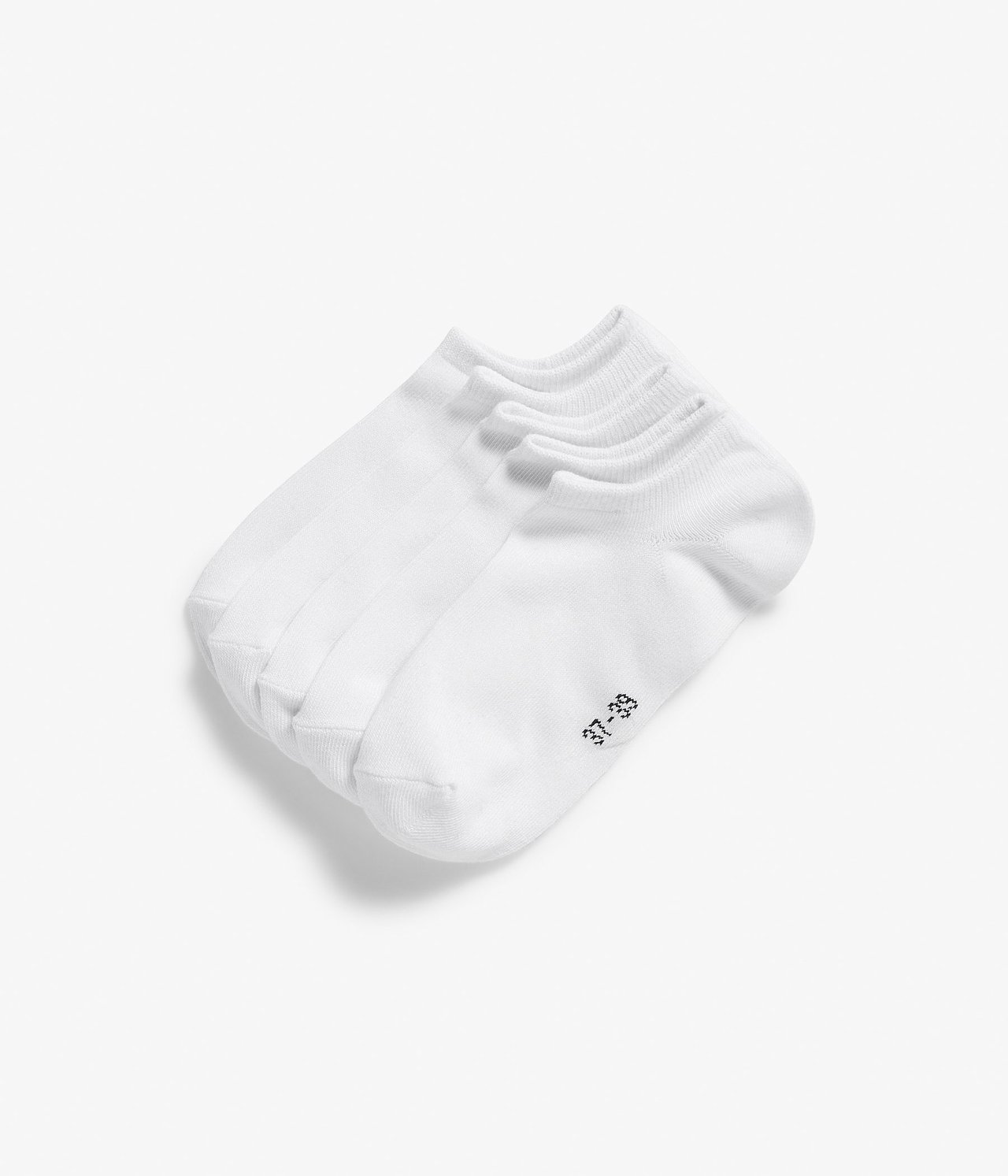 Widok z góry na pięć par białych bawełnianych skarpetek stoperek, starannie ułożonych.