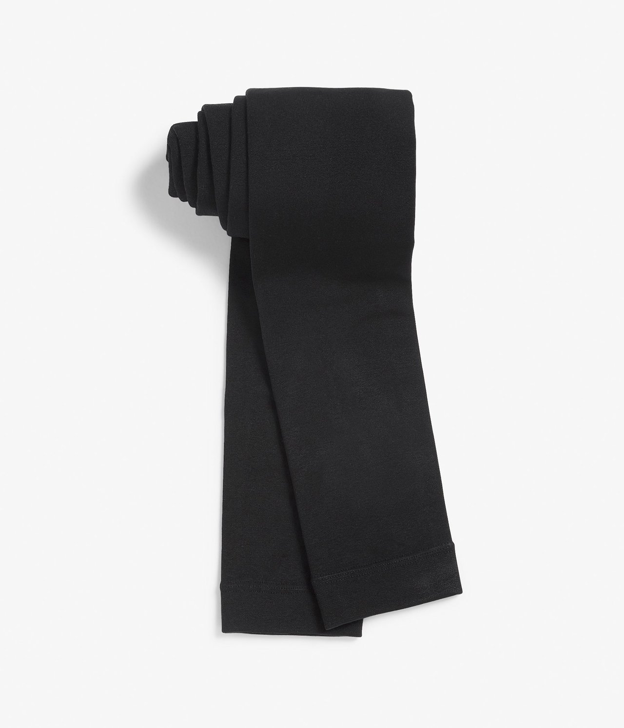 Ylhäältä näkymä mustista, yksivärisistä, taitetuista leggingseistä, joissa on harjattu sisäpuoli.