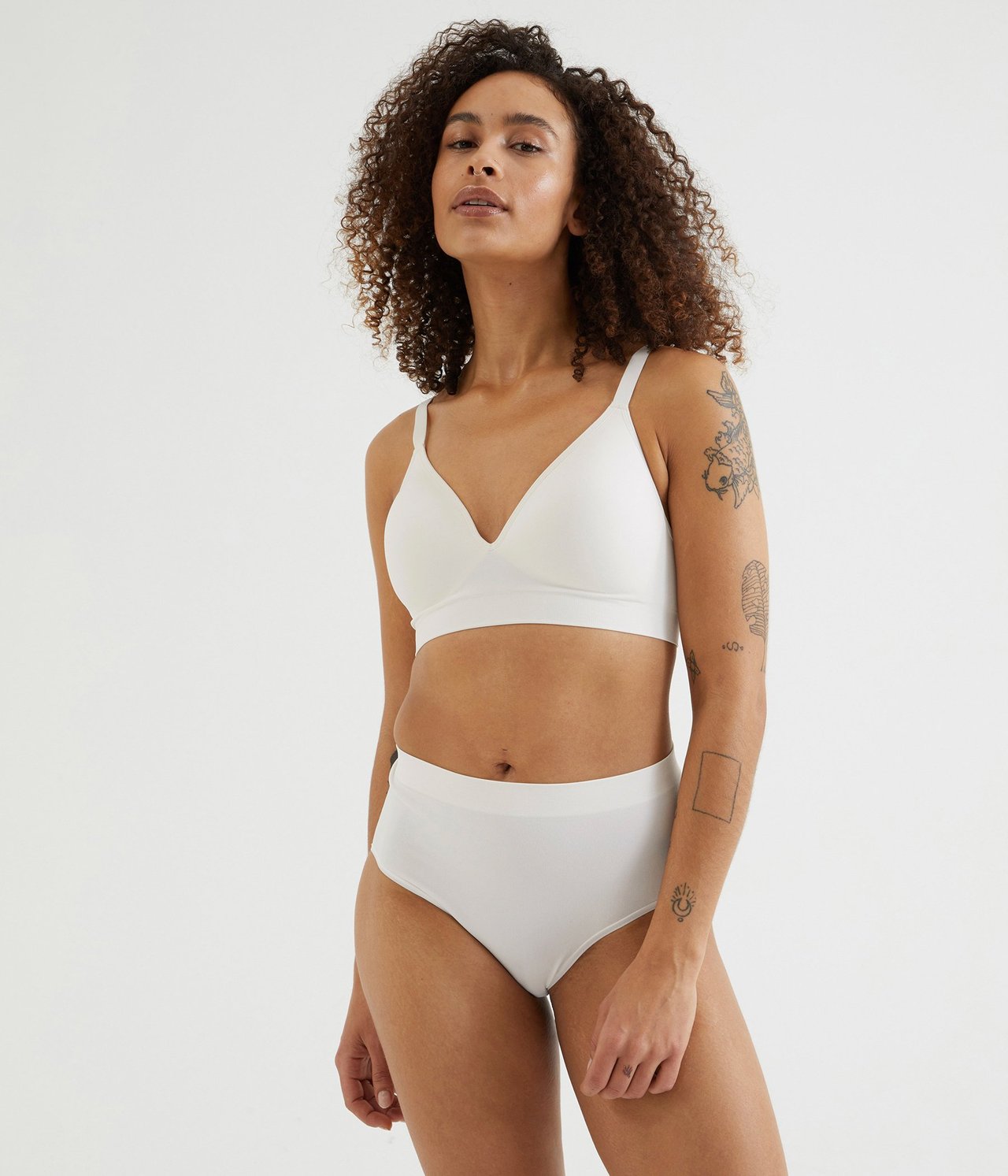 Forfra, kvinne i hvite sømløse høytrusede truser og matchende hvit sømløs BH.
