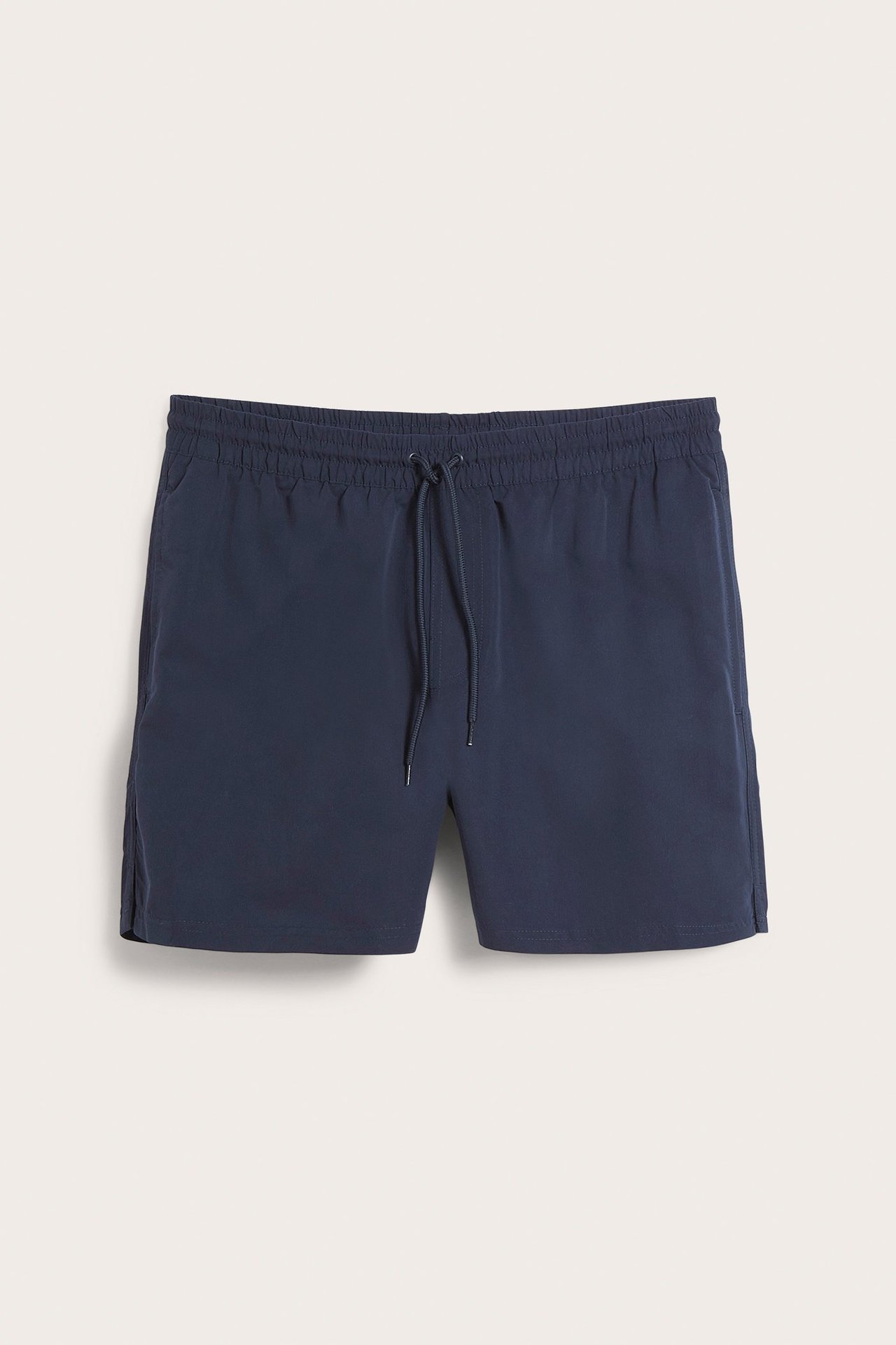 Forfra, mørkeblå badeshorts for menn i resirkulert polyester med strikk, snøring og sidelommer.