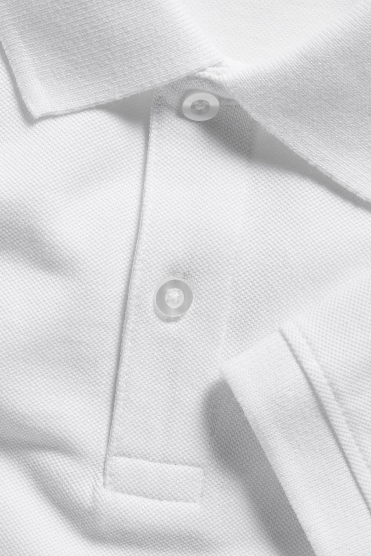 Zbliżenie białej męskiej koszulki polo z bawełny piqué, z kołnierzykiem i dwoma białymi guzikami.