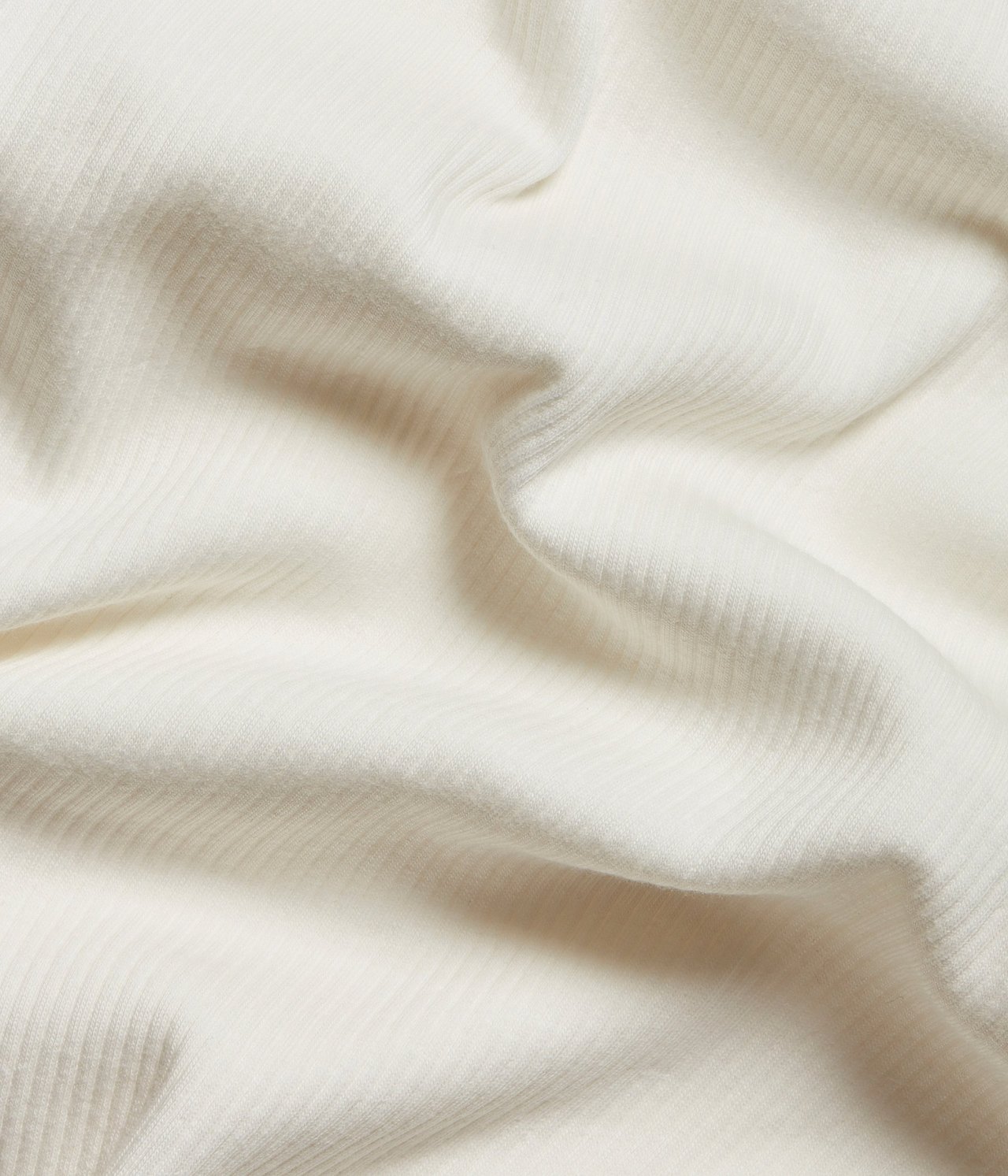 Nærbilde av offwhite ribbestoff til en langermet topp.