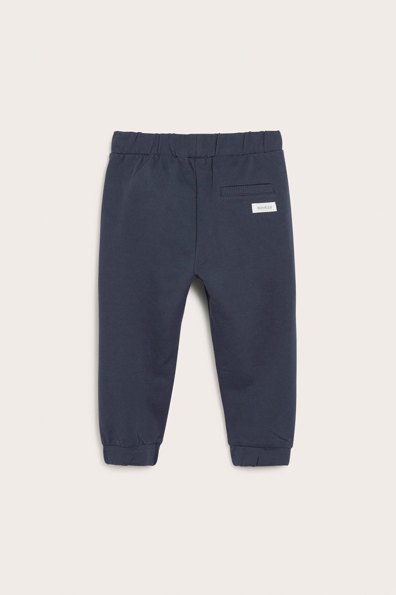 Bakfra, mørkeblå joggebukse for barn med elastisk midje, mansjetter ved anklene og en liten baklomme.