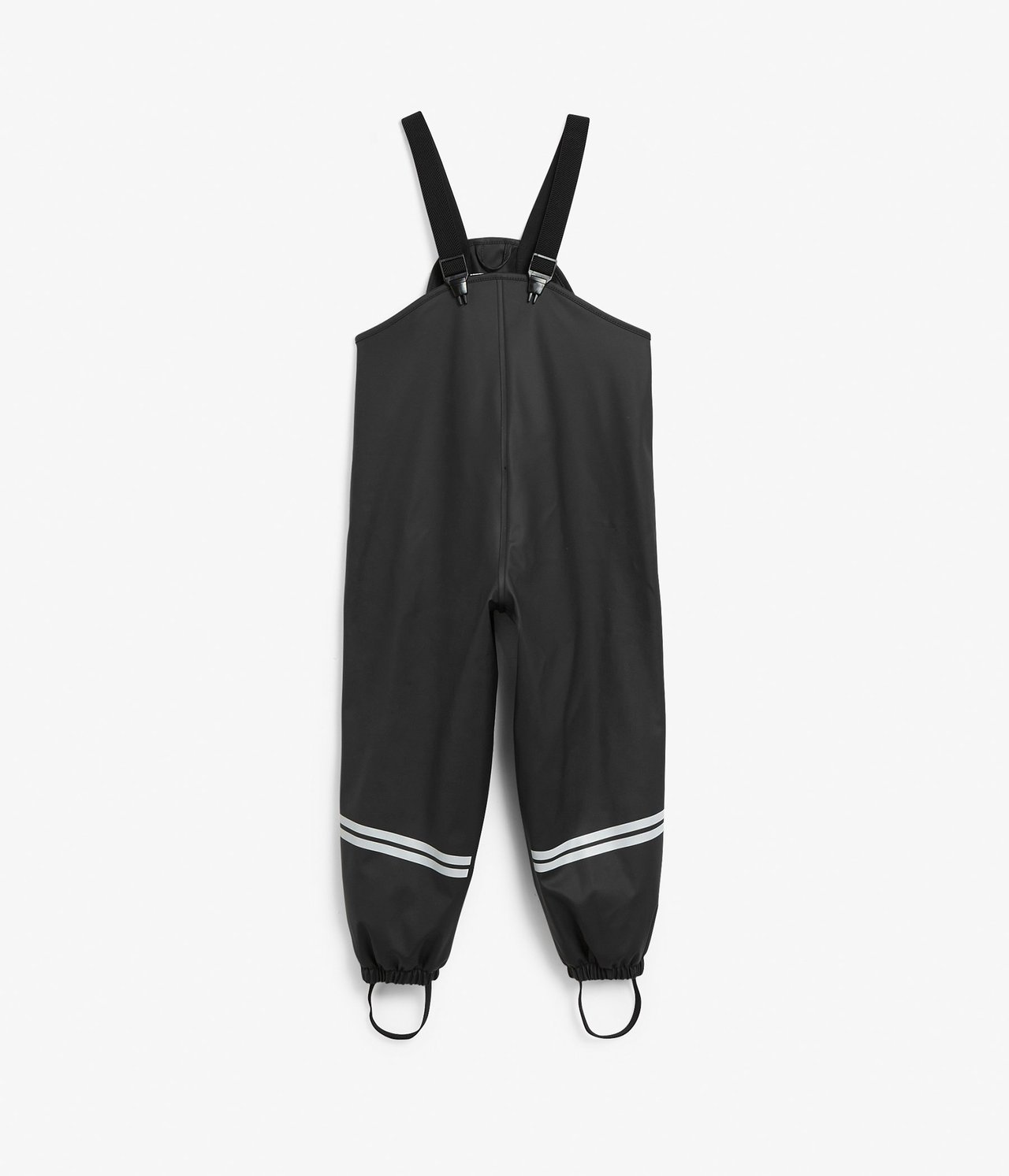 Framifrån: svarta regnbyxor för barn med hängslen, reflexränder och elastiska fothällor.