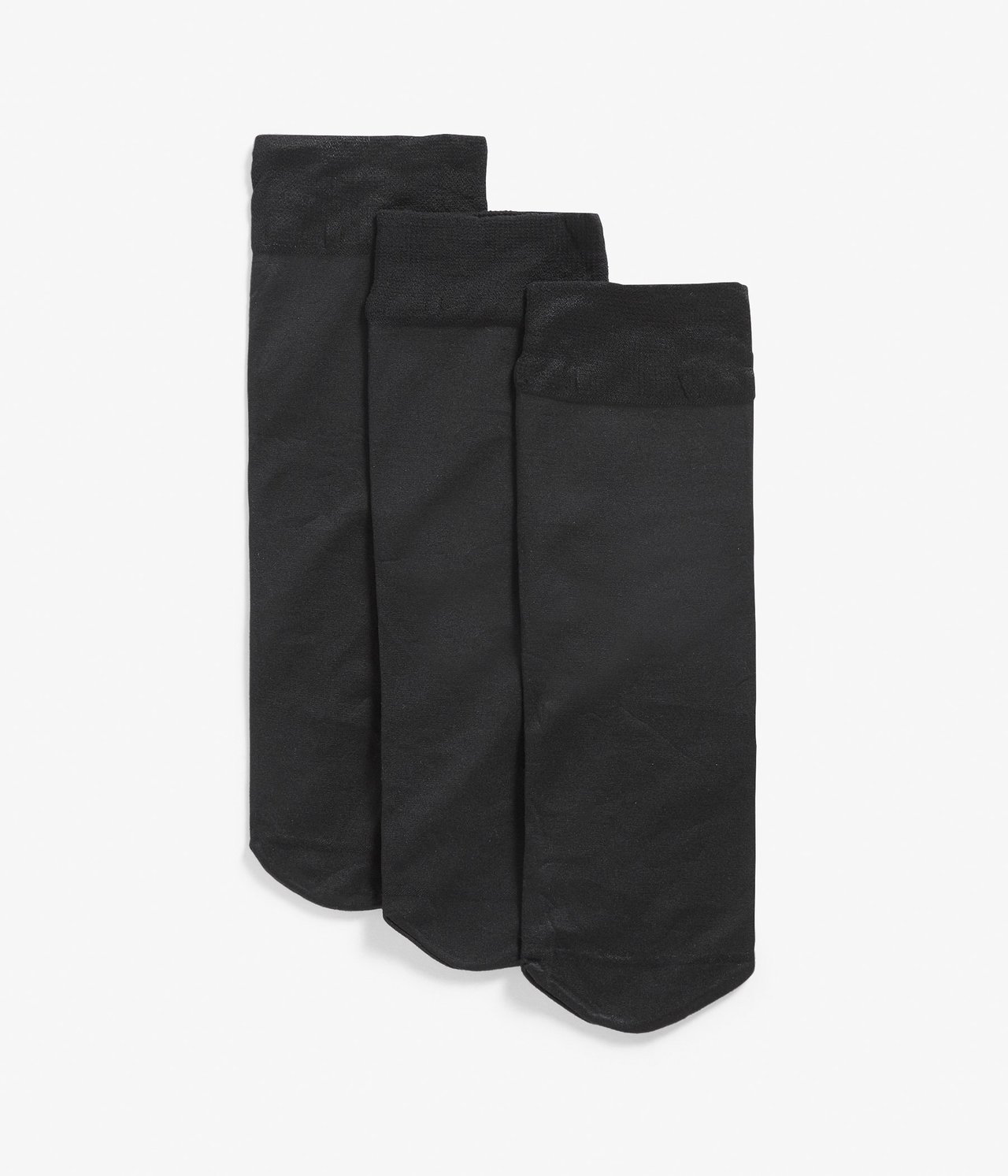 Widok z przodu trzech par czarnych skarpet nylonowych, ułożonych płasko.