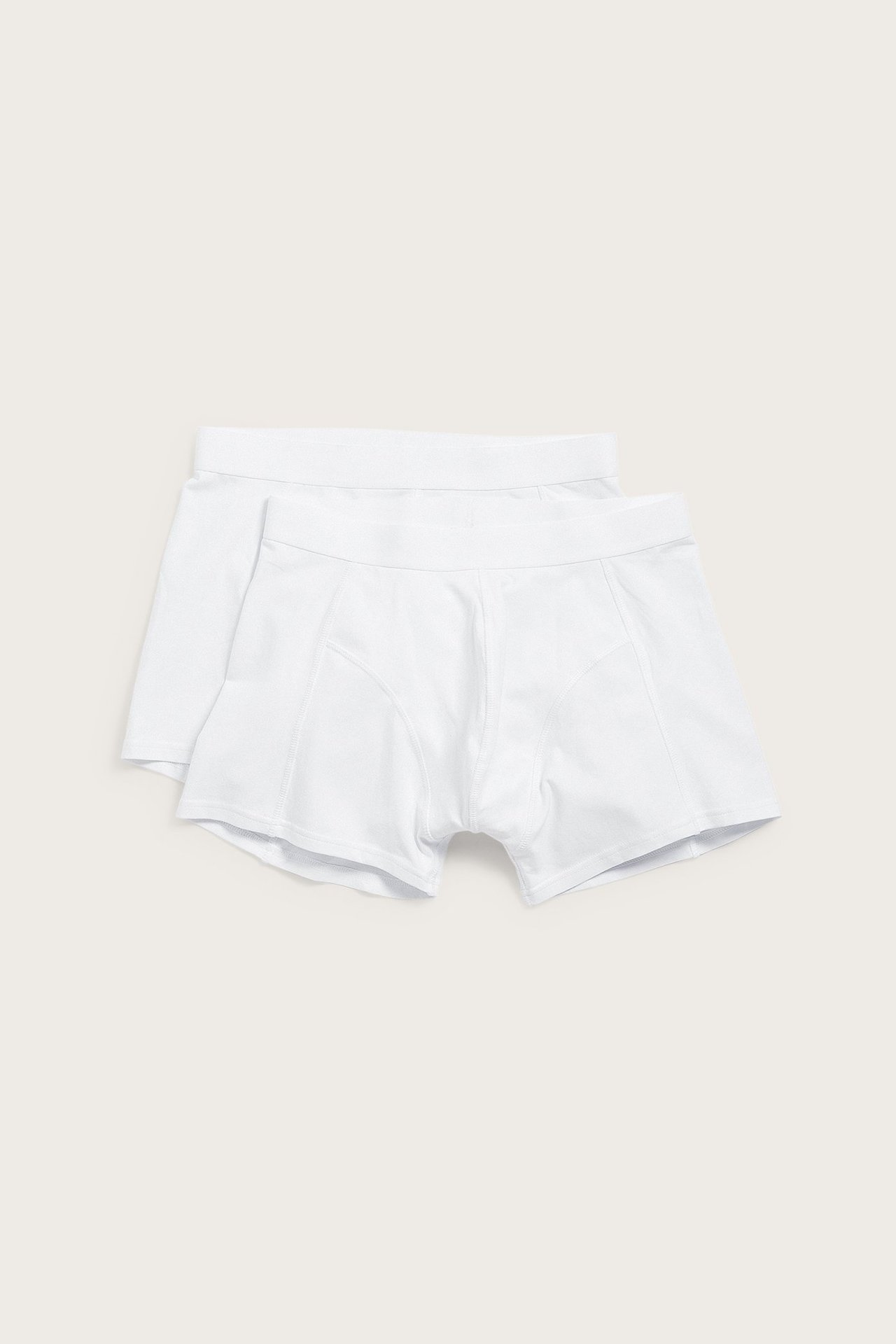 Widok z przodu: dwie białe, gładkie bokserki męskie z bawełny o normalnej nogawce, ułożone.