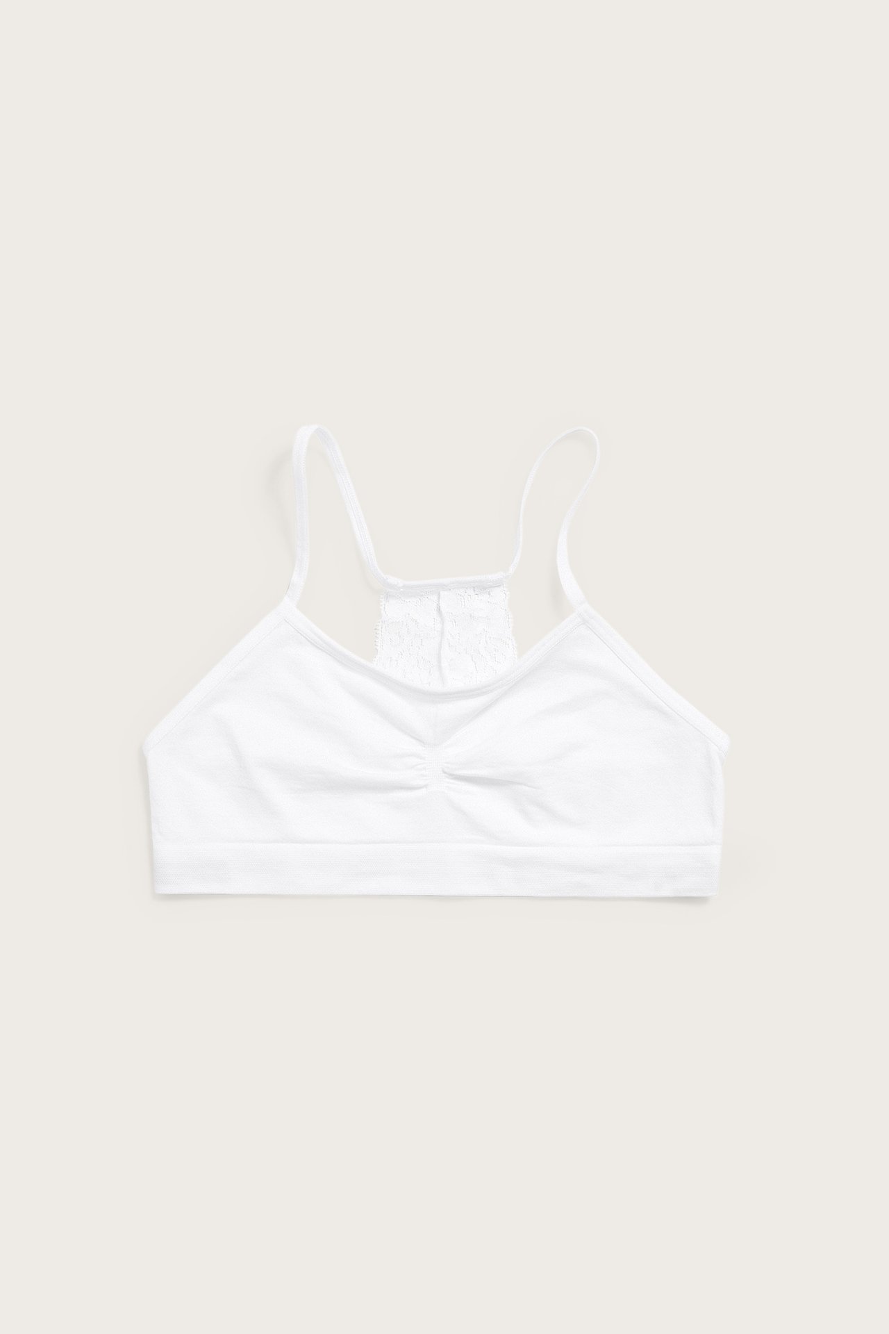 Valkoinen saumaton toppi ohuilla olkaimilla, rypytetyllä etuosalla ja pitsisellä selällä, edestä.