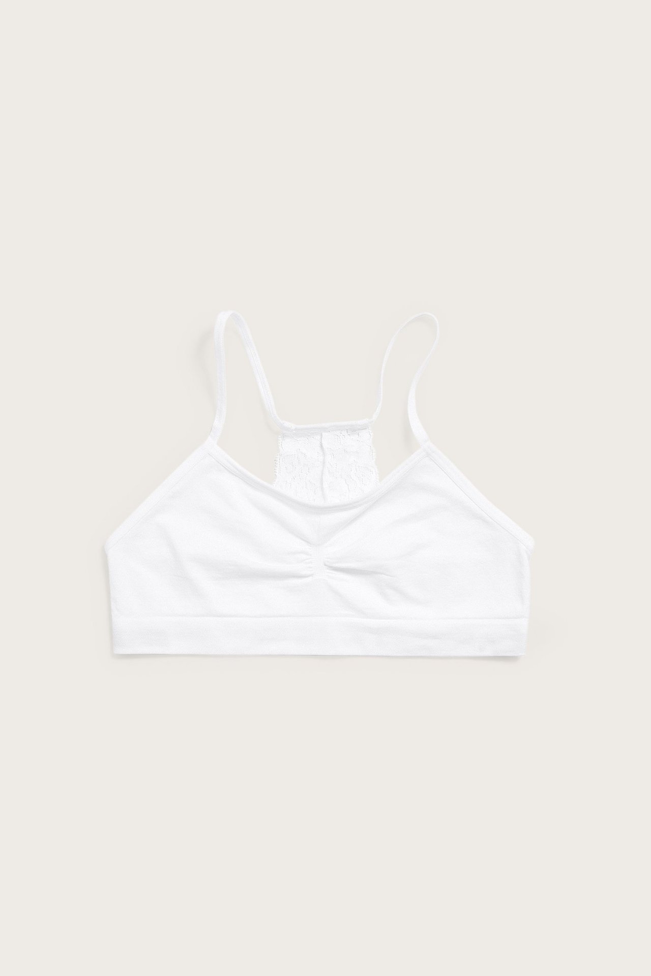 Valkoinen saumaton toppi ohuilla olkaimilla, rypytetyllä etuosalla ja pitsisellä selällä, edestä.