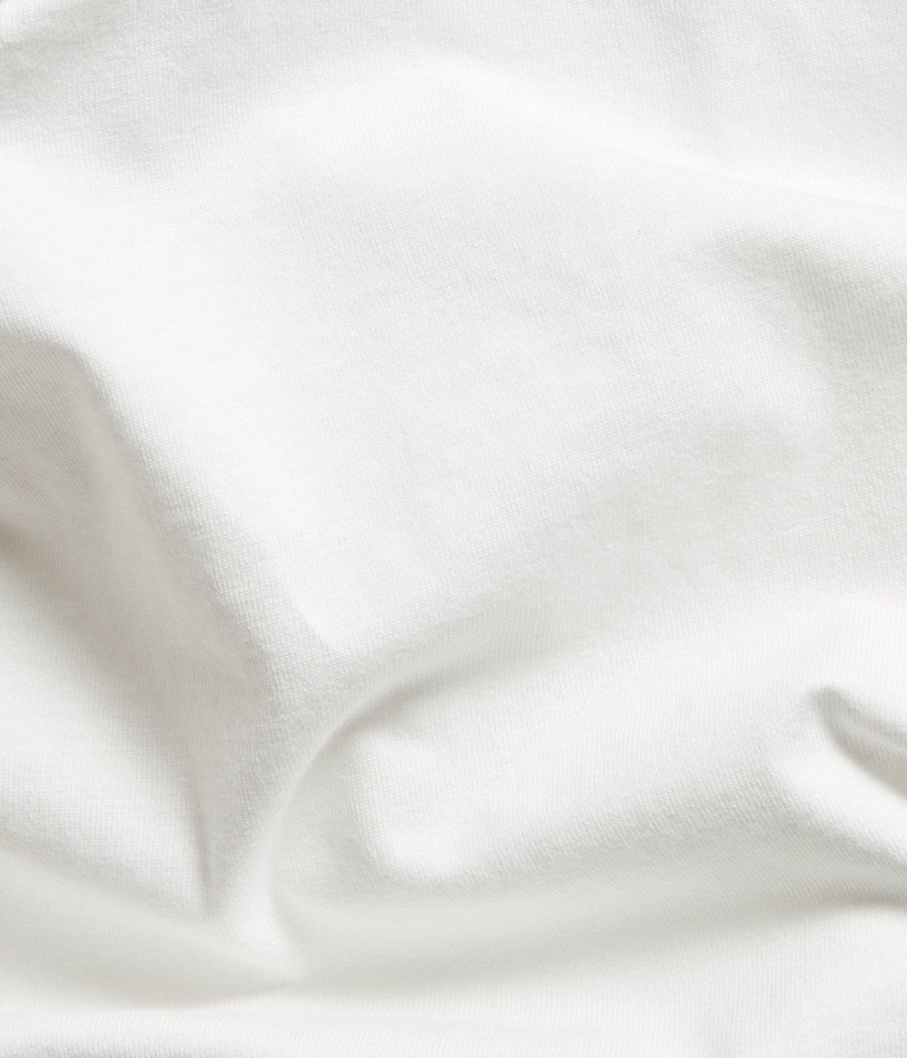 Zbliżenie na ecru, jednolity bawełniany materiał na top, z delikatną teksturą.