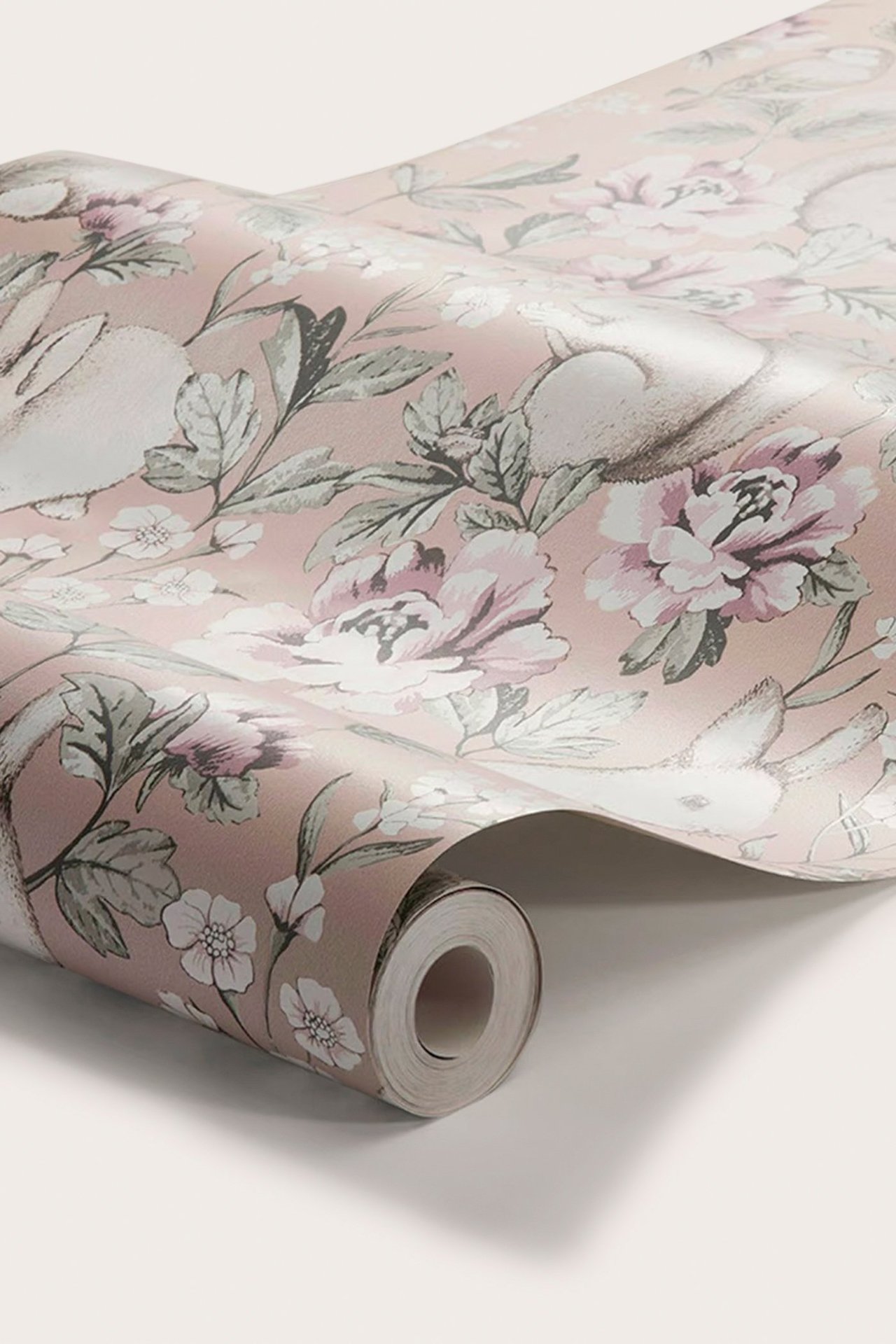 Zbliżenie zwiniętej różowej tapety z wzorem białych królików i różowych kwiatów.