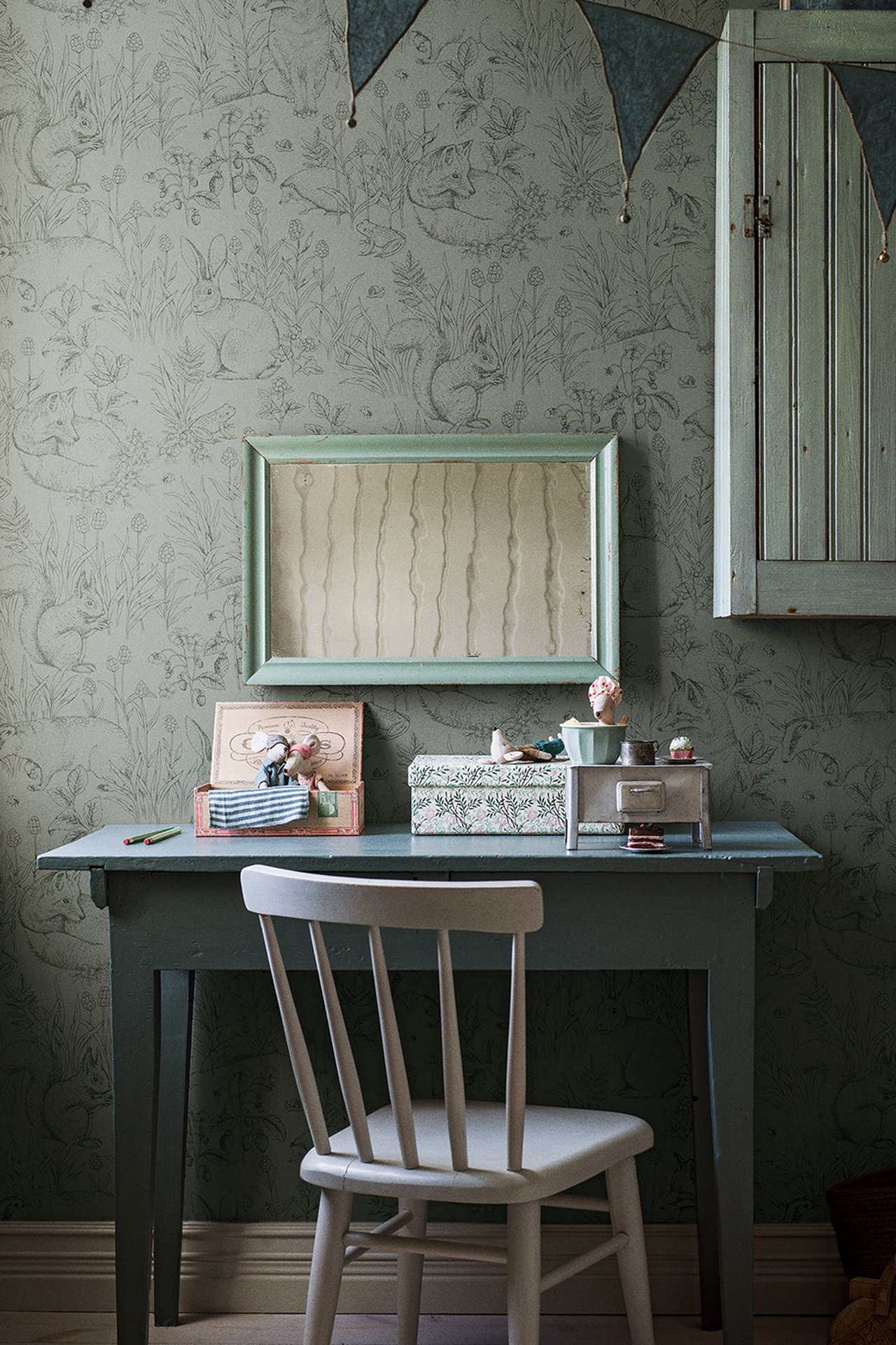 Frontvisning av grønn non-woven tapet med detaljert skogsdyrmønster som dekker en vegg.