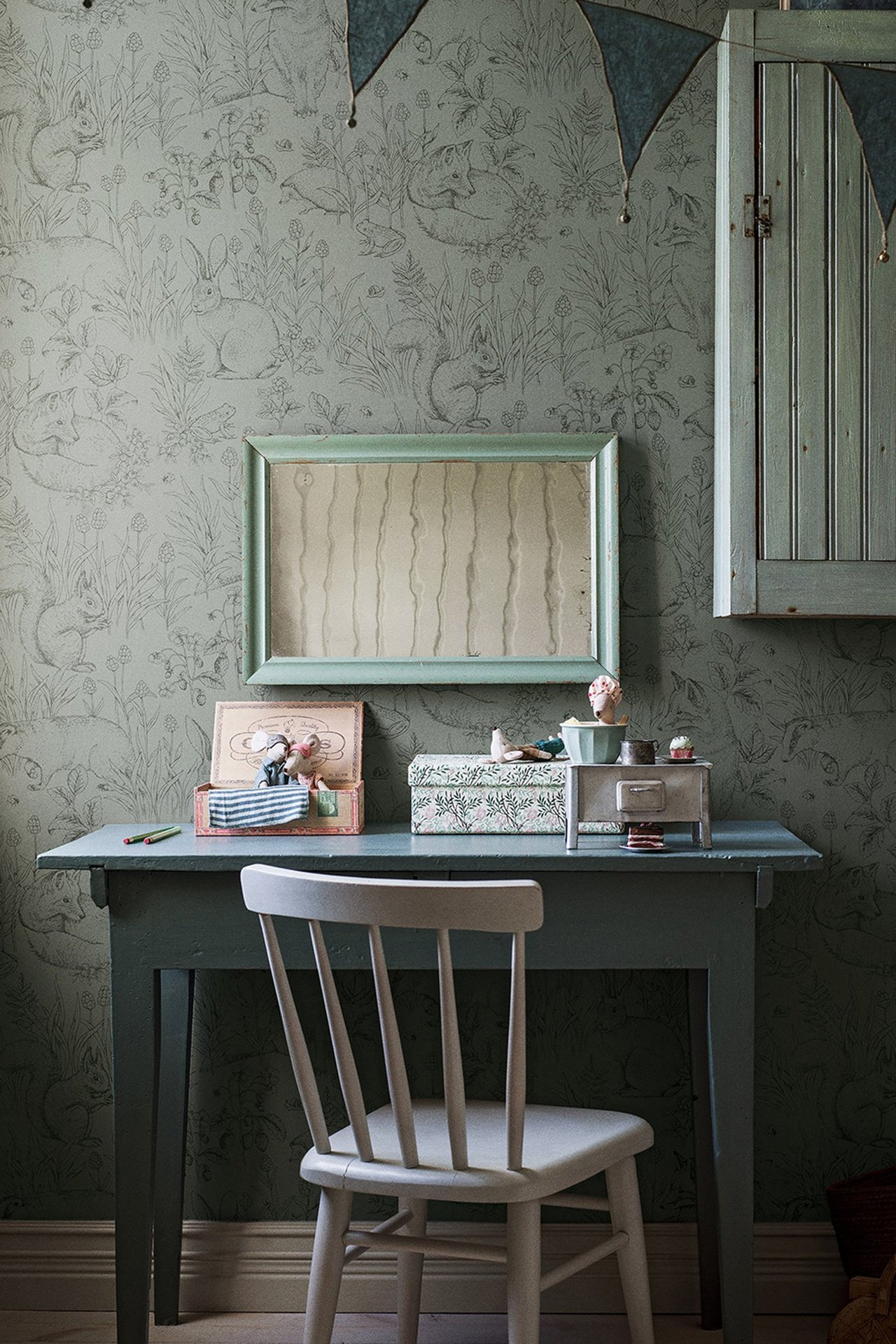 Frontvisning av grønn non-woven tapet med detaljert skogsdyrmønster som dekker en vegg.