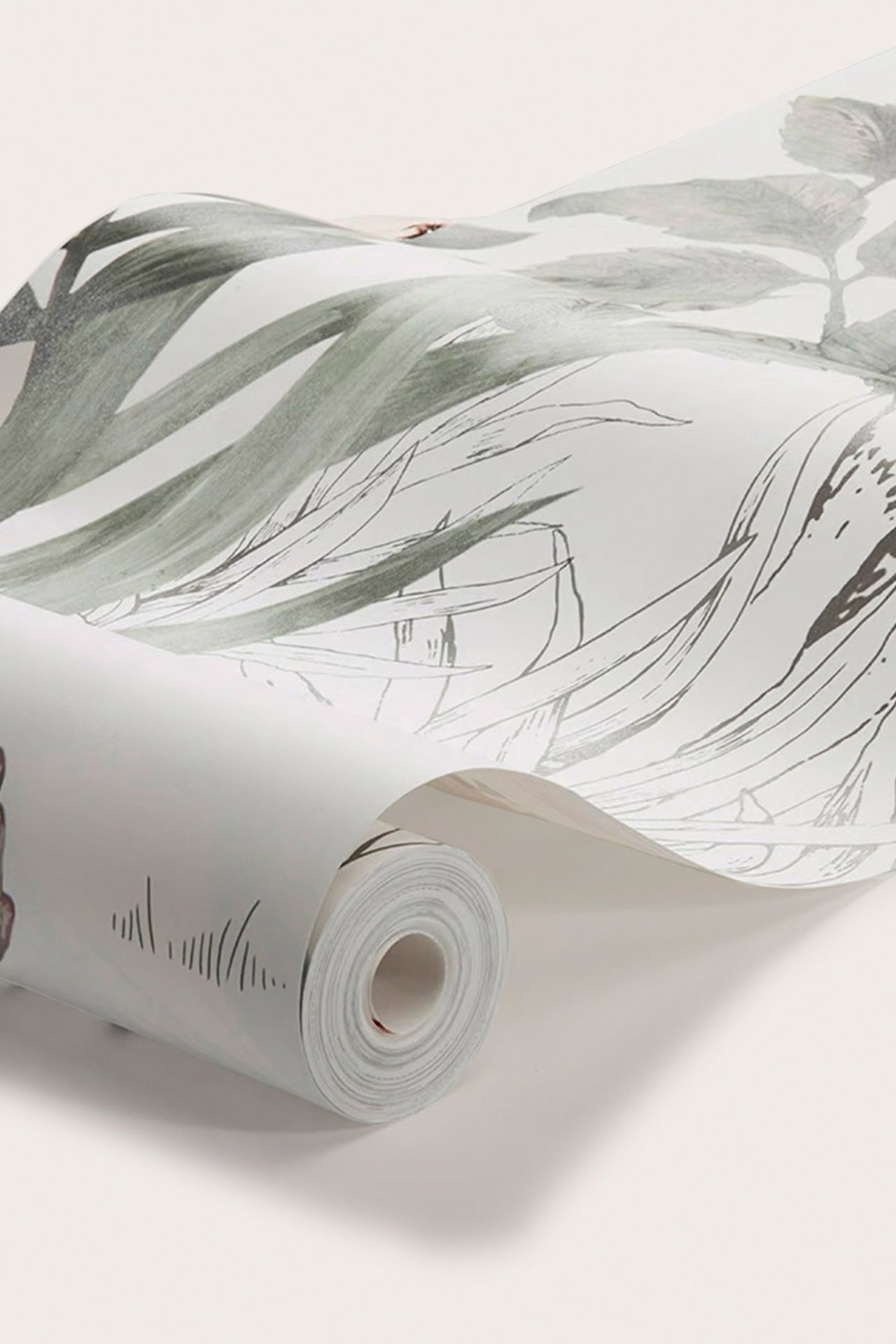 Nærbilde av en delvis utrullet non-woven tapet i lys grå med grågrønt skog- og subtilt korallfarget dyremønster.