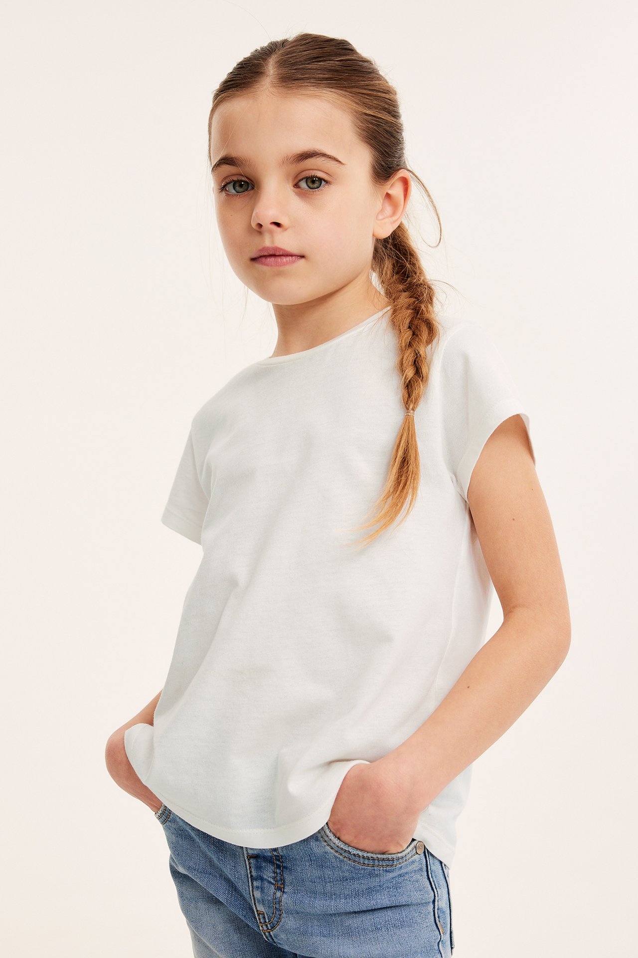 Barnkille i vit T-shirt med rund hals, kort ärm, bomull, enfärgad, frontvy.
