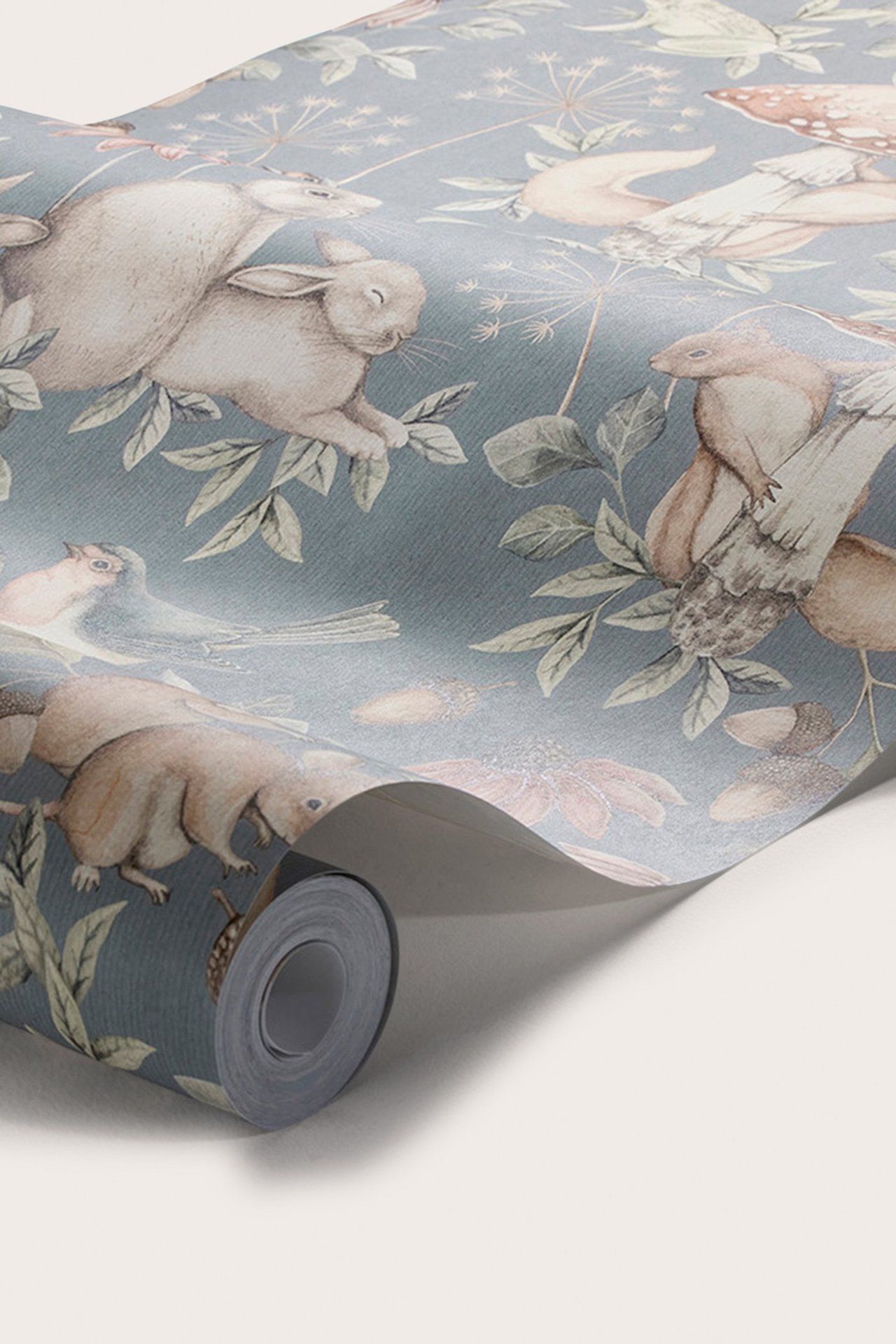 Nærbilde av en blå tapetrull med et gjentakende mønster av skogsdyr og planter.