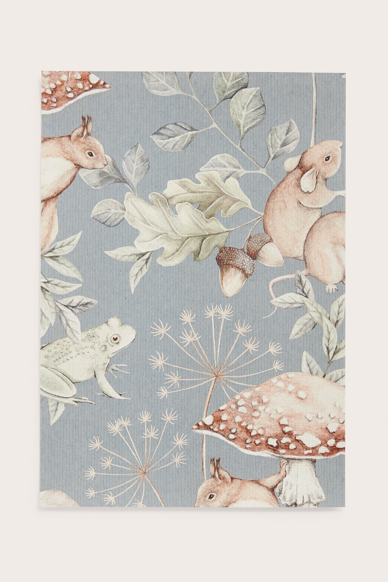 Framsida av ett blått mönstrat tapetprov med skogens djur, löv, ekollon och svampar.