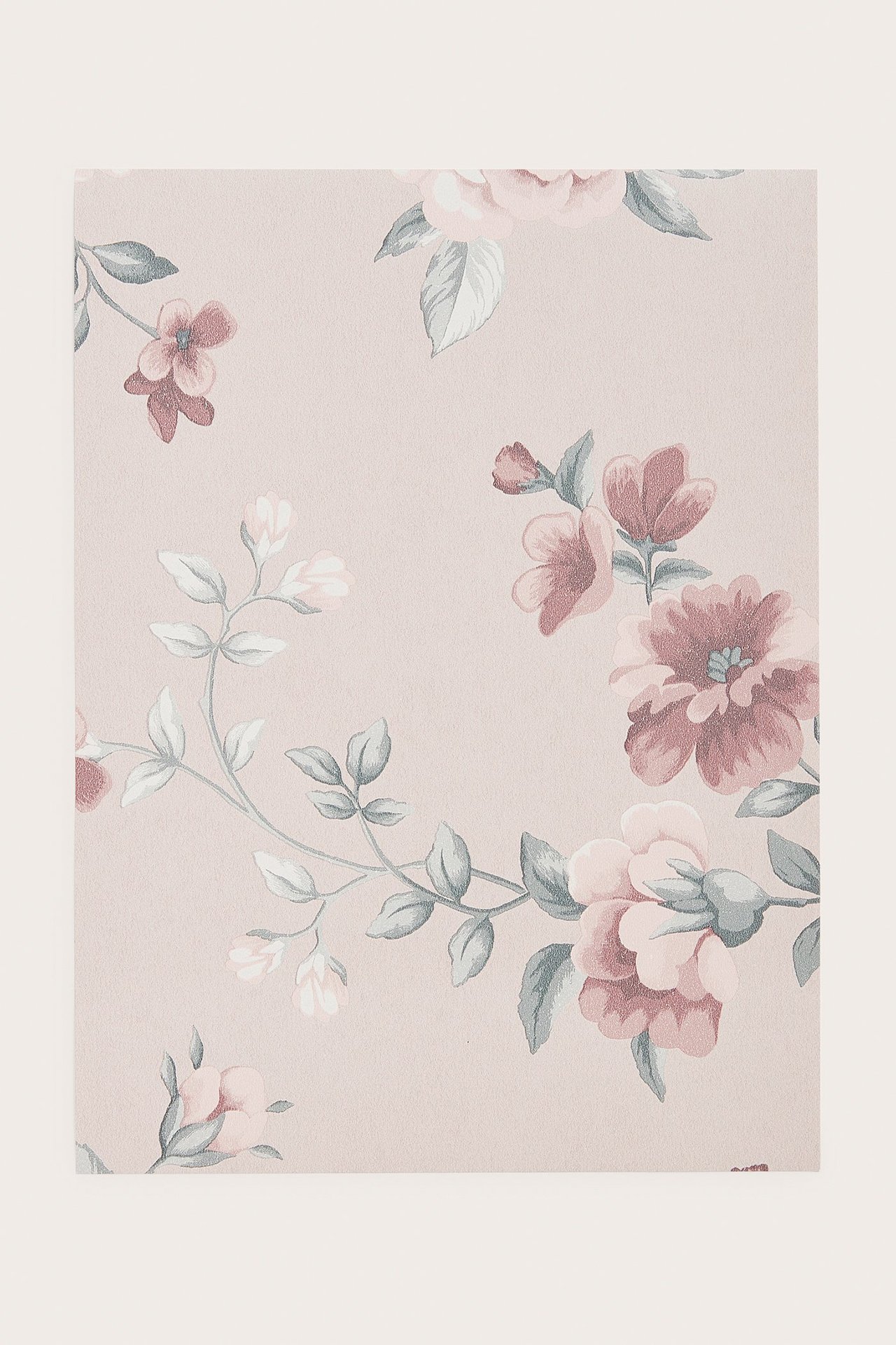 Fullt bilde av en lys rosa non-woven tapetprøve med blomstermønster.