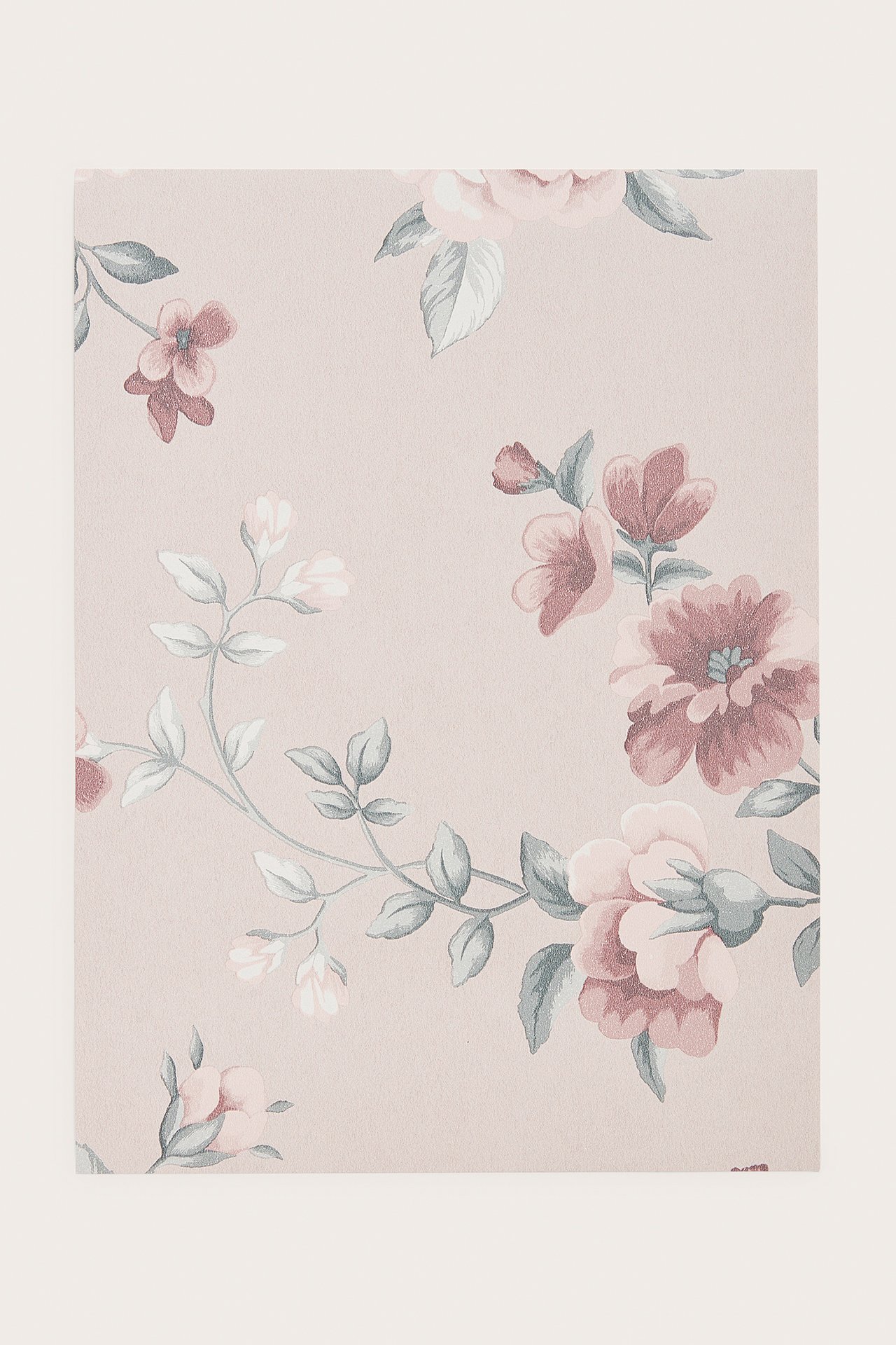 Fullt bilde av en lys rosa non-woven tapetprøve med blomstermønster.