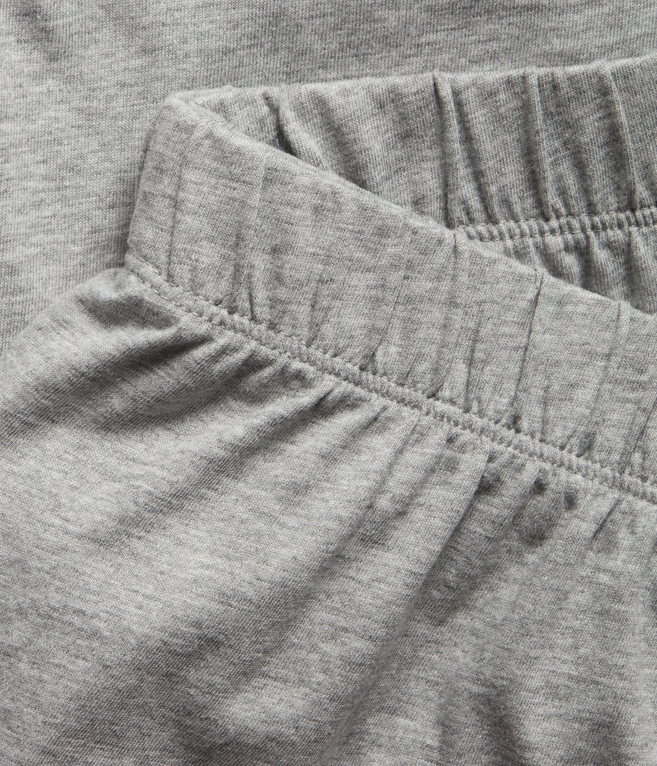 Zbliżenie na jasnoszare melanżowe szorty piżamowe z dżerseju z elastycznym pasem.