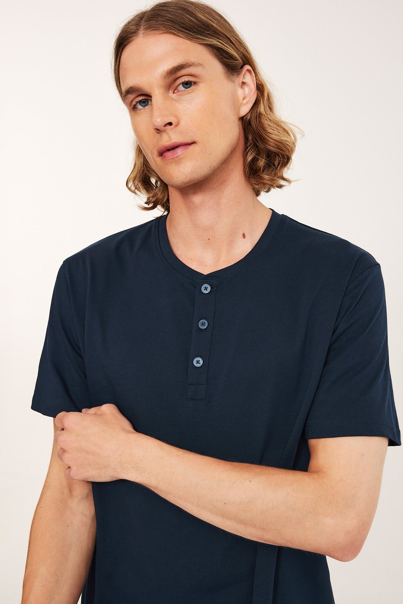 Widok z przodu mężczyzny w granatowej, bawełnianej koszulce piżamowej z krótkim rękawem i guzikami.