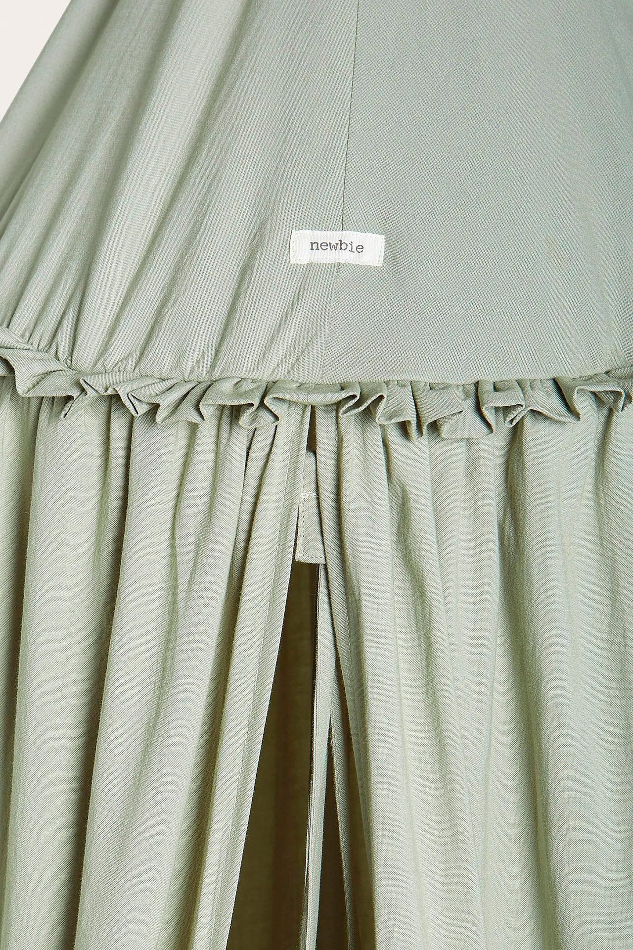 Zbliżenie z przodu ciemnozielonego namiotu do czytania z falbanką u góry i metką 'newbie'.