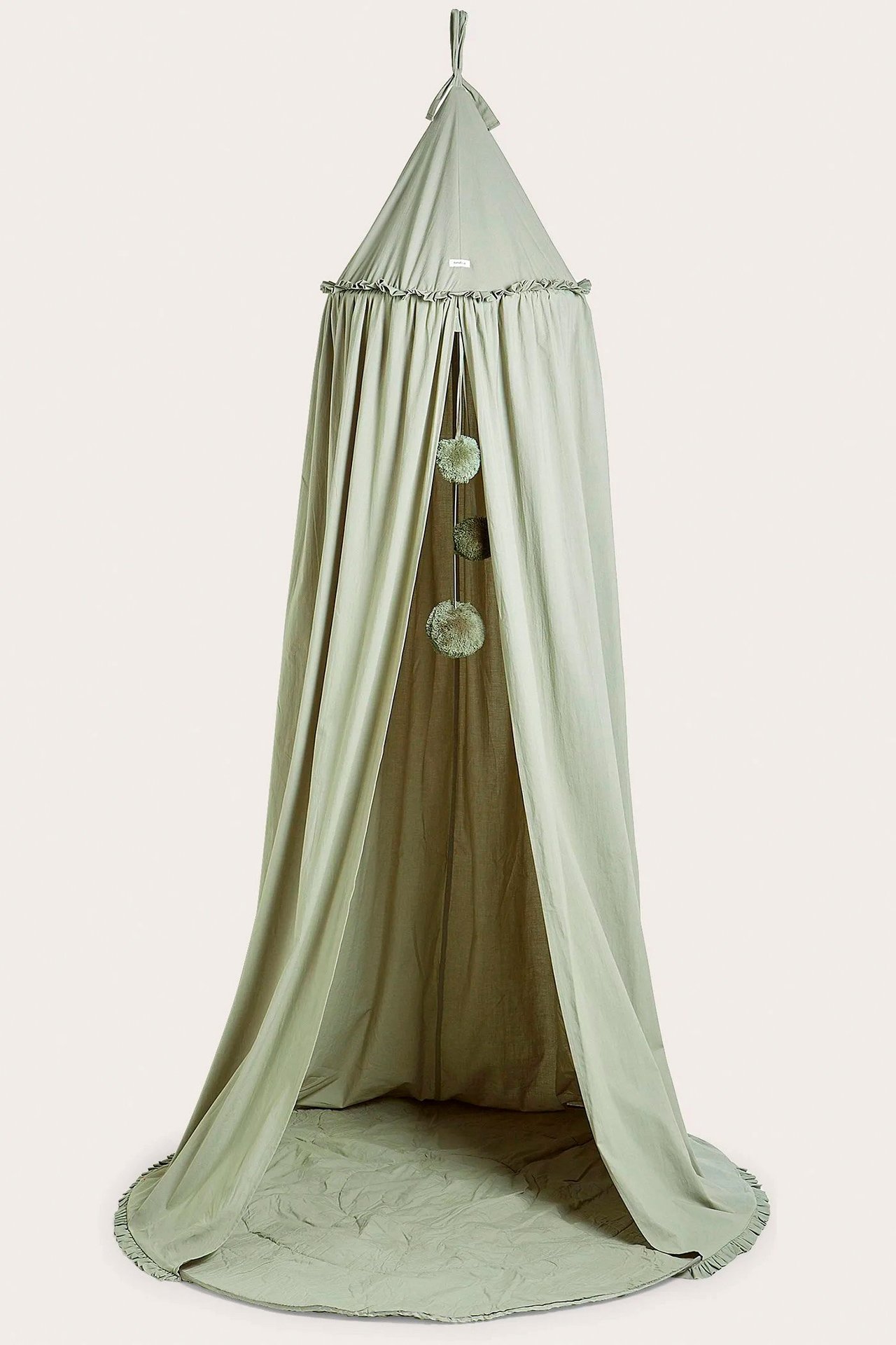 Z przodu: ciemnozielony namiot do czytania z falbanką, wiszącymi pomponami i wyściełanym dnem.