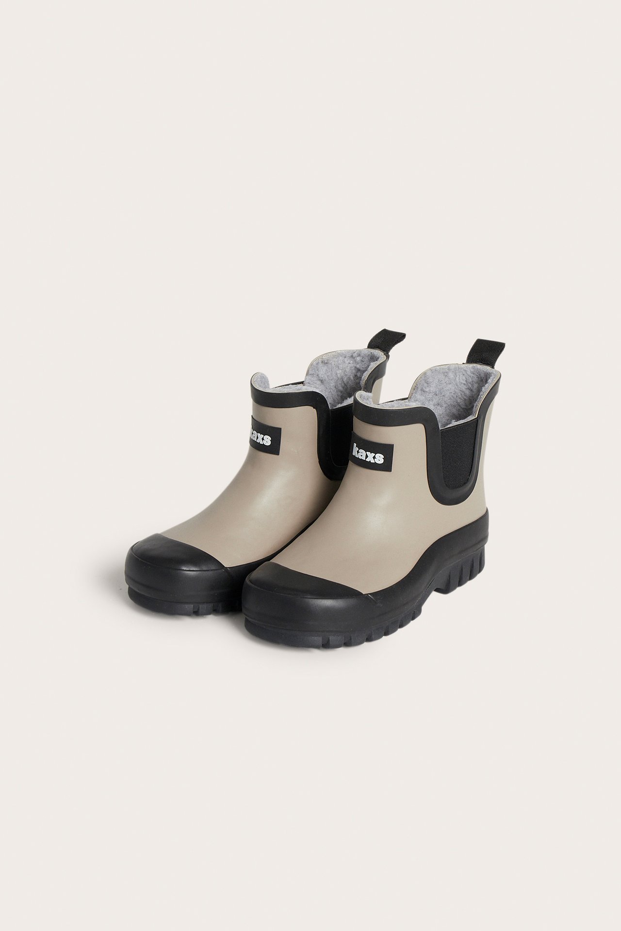 Framsida: beiga fodrade Chelsea-gummistövlar med svarta sulor, tåhätta, resår och Kaxs-logga.