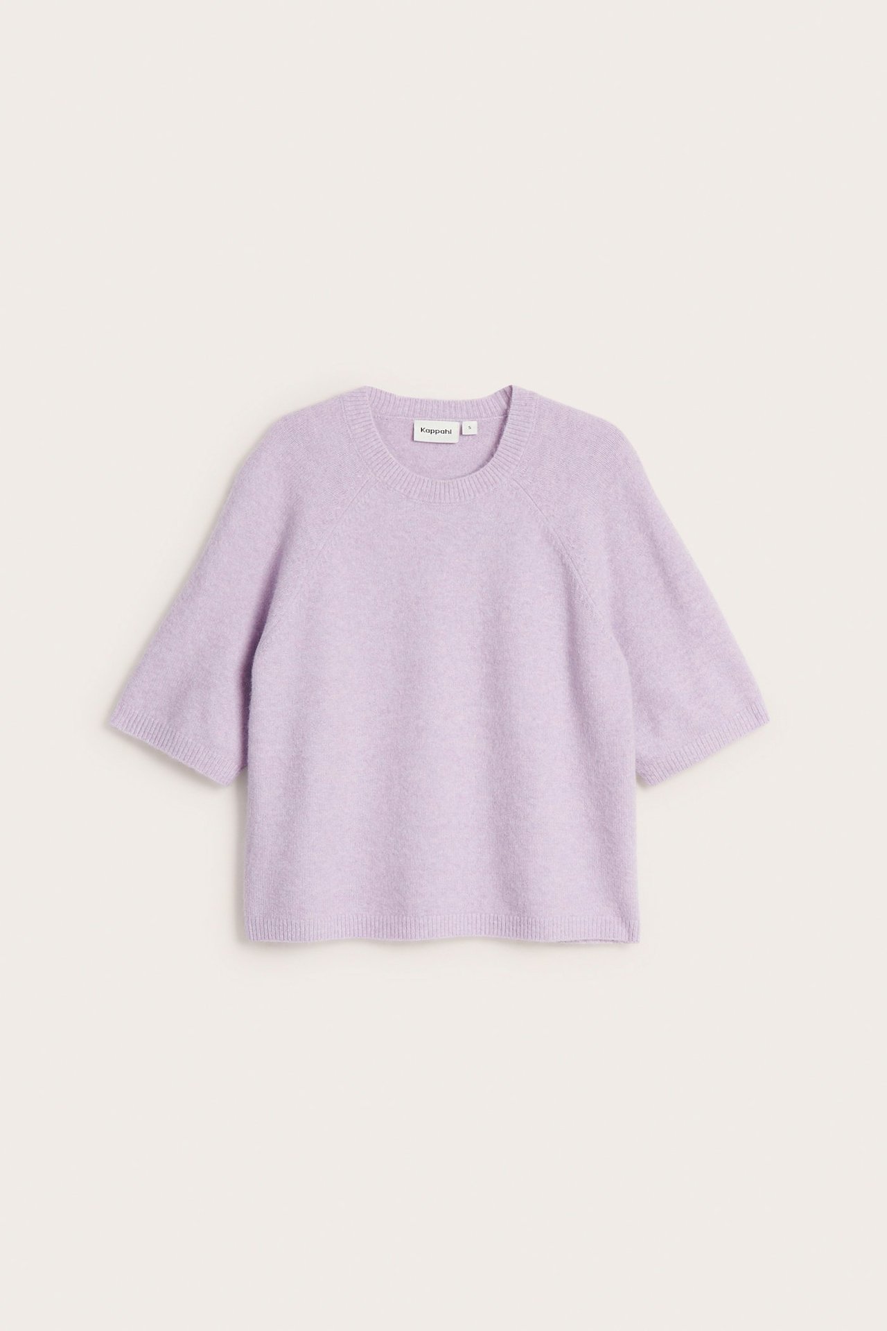 Edestäpäin, oversized vaaleanlila neulottu t-paita lyhyillä raglanhihoilla ja pyöreällä pääntiellä.