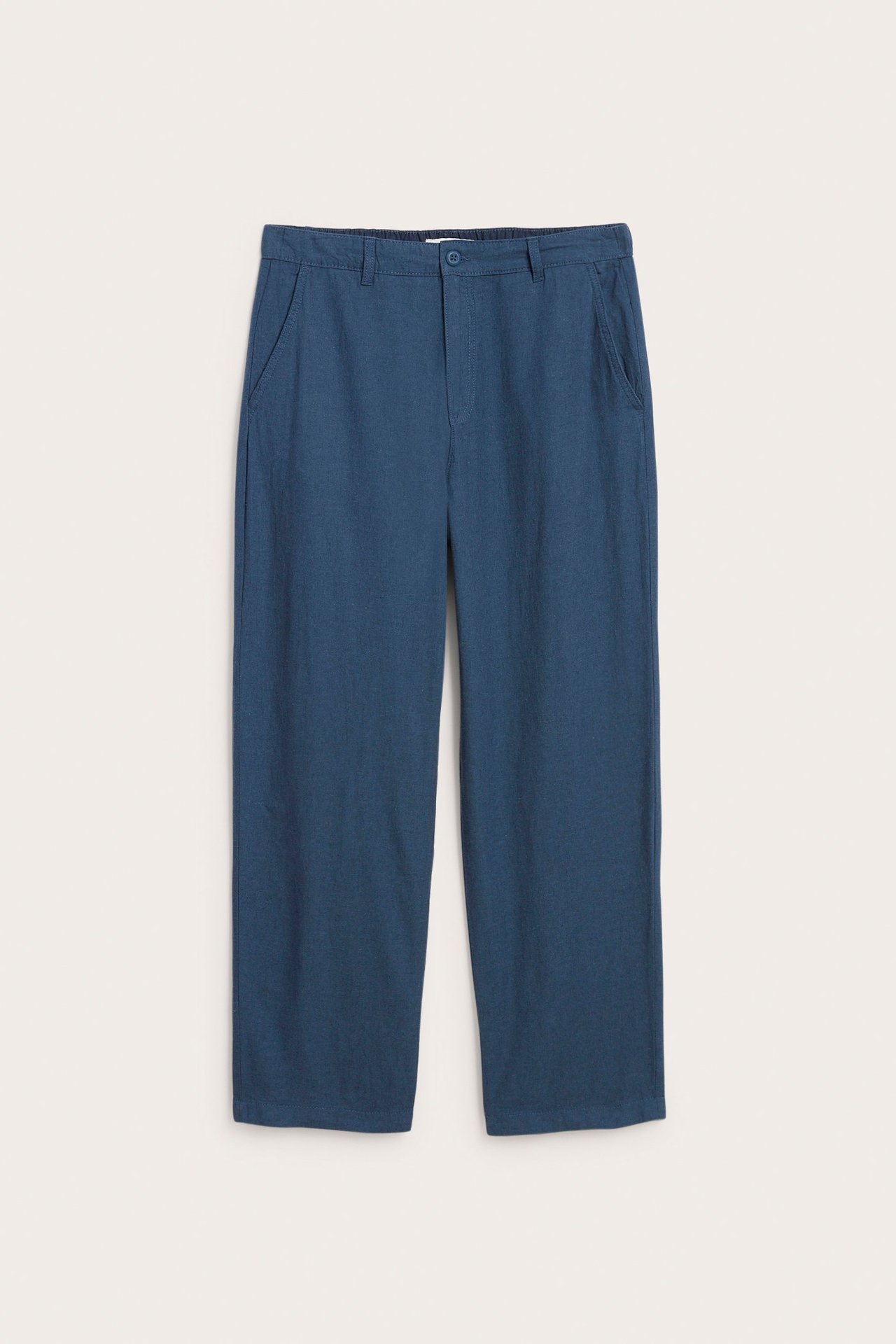 Widok z przodu męskich niebieskich spodni regular fit z mieszanki lnu, z guzikiem i kieszeniami bocznymi.