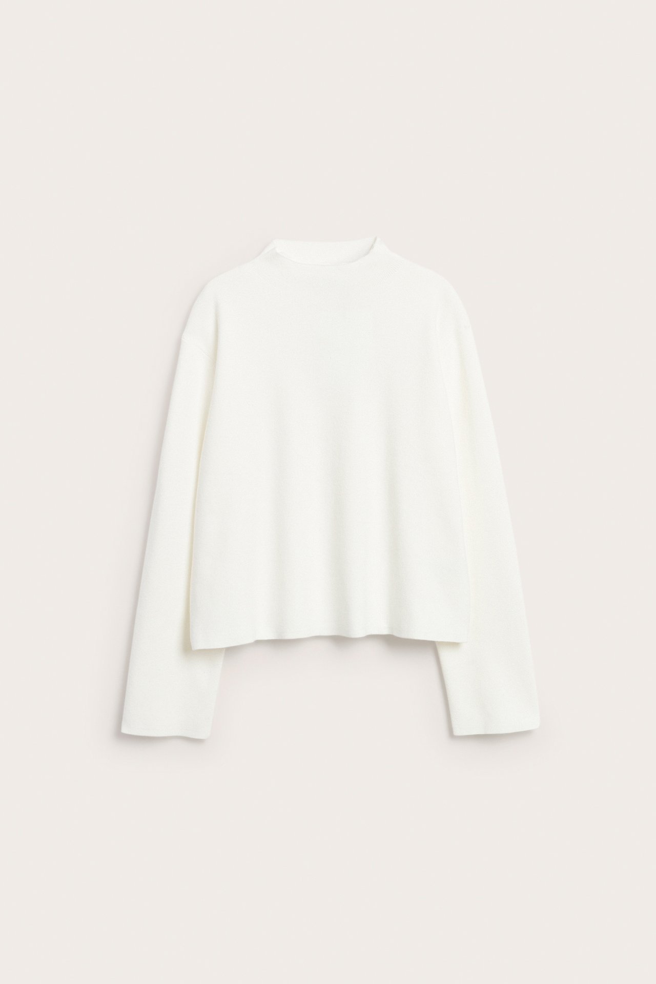 Widok z przodu na kremowy sweter z dzianiny ze stójką, długimi rękawami i luźnym krojem.