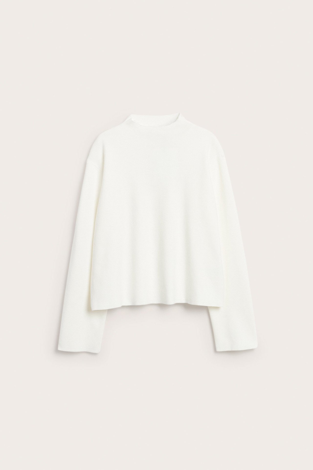 Widok z przodu na kremowy sweter z dzianiny ze stójką, długimi rękawami i luźnym krojem.