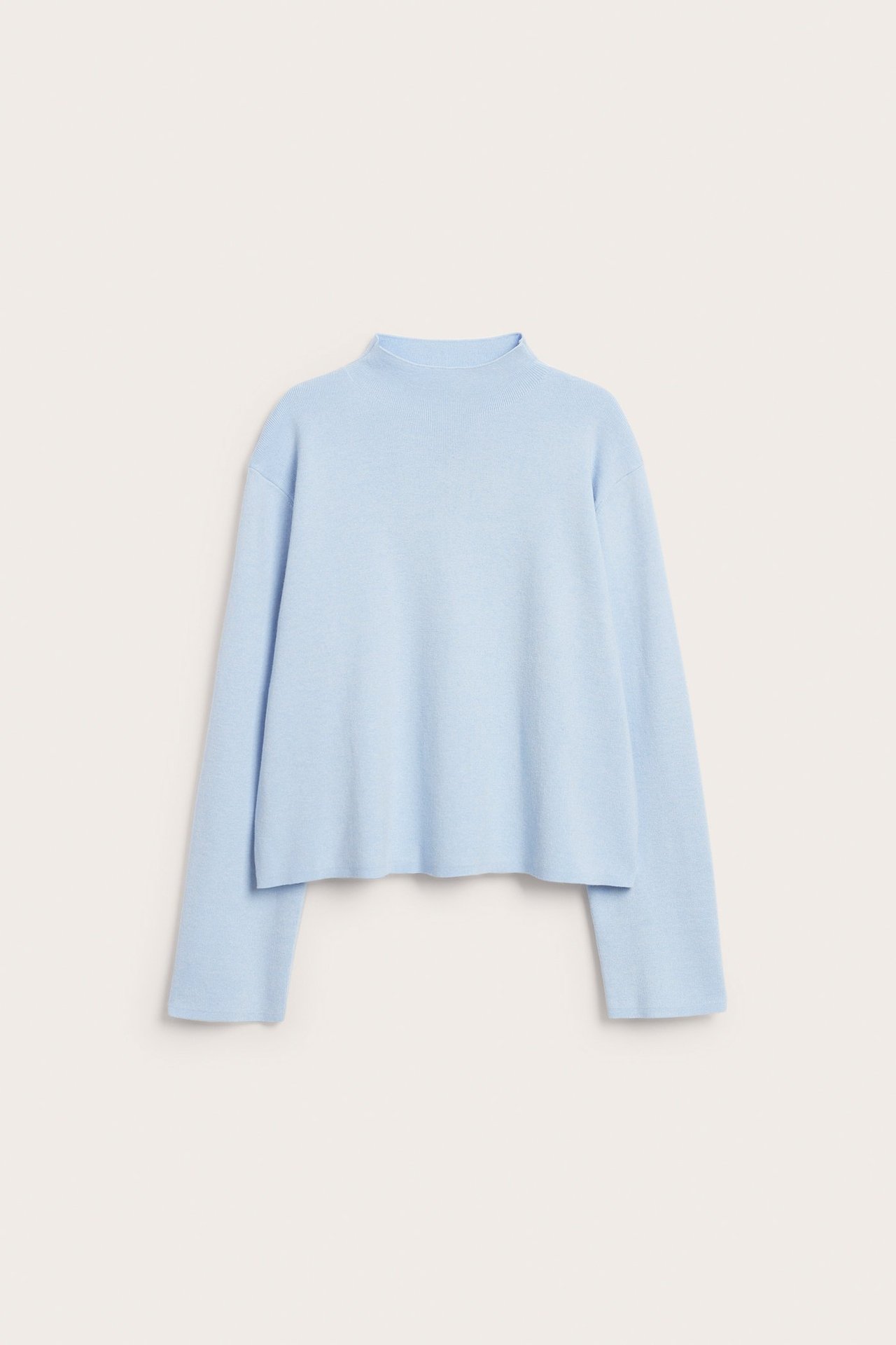 Widok z przodu jasnoniebieskiego jednolitego swetra dzianinowego ze stójką i luźnym krojem.