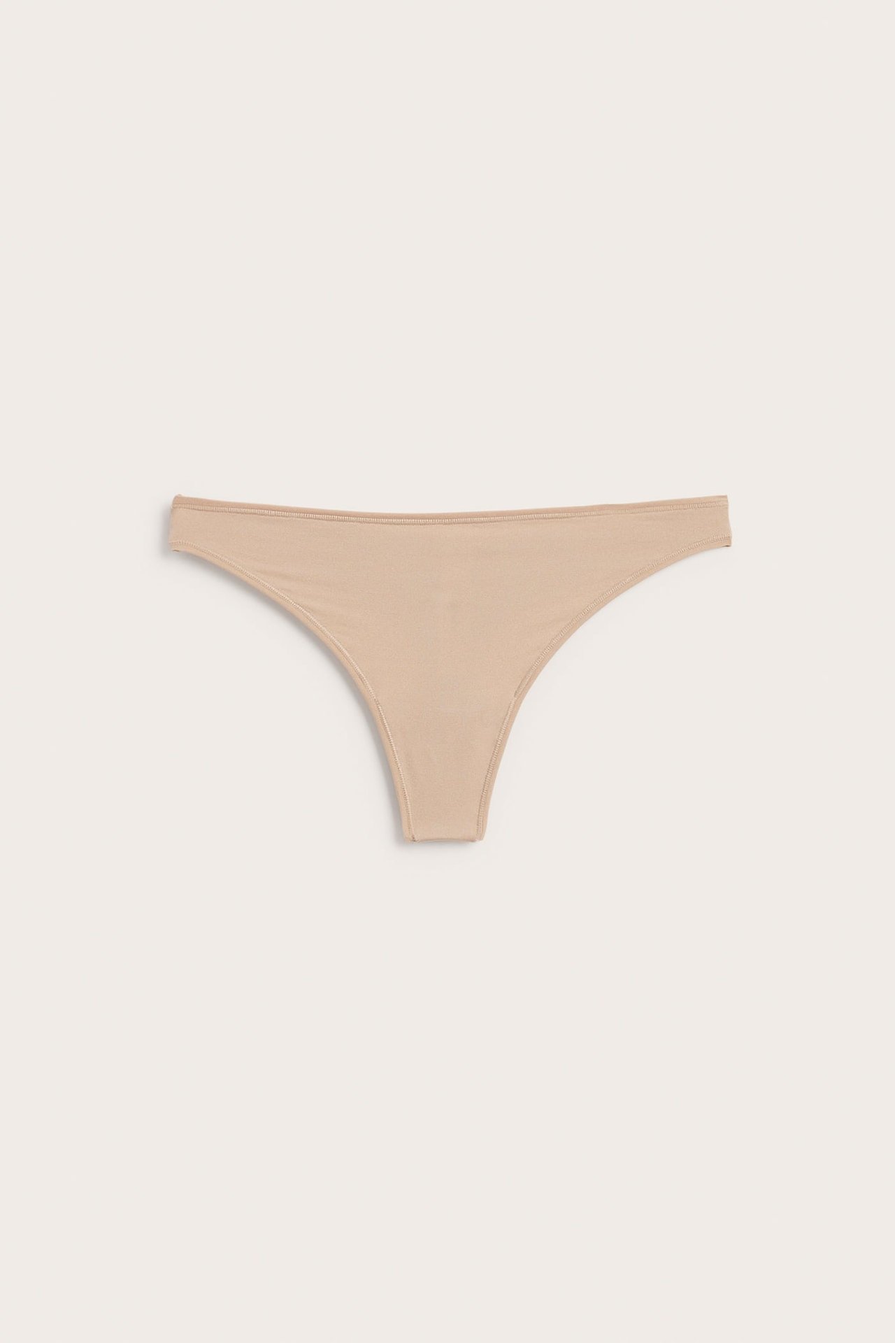 Frontbilde av beige stringtruse i glatt stoff.