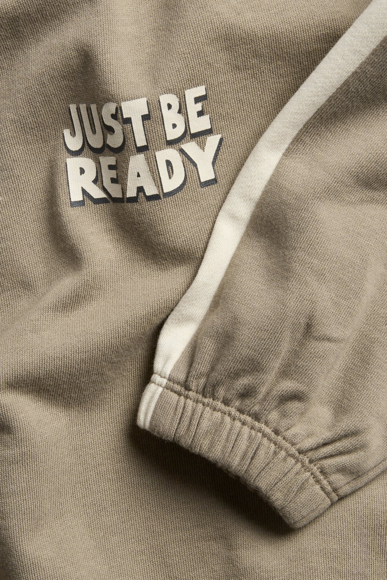 Beige puuvillainen collegepaita kontrastivärisillä helmauksilla, printti ja ribbot pään- ja hihansuut.