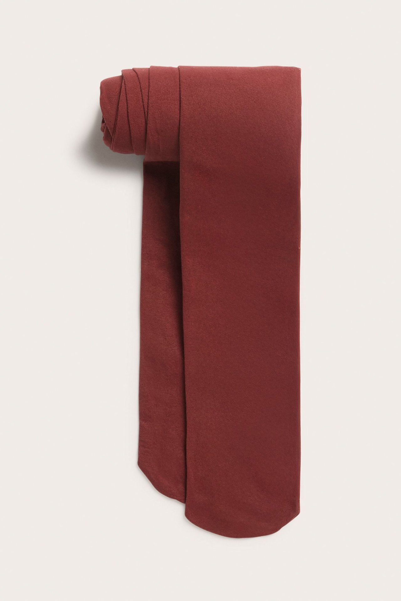 Taitettujen tummanpunaisten yksiväristen 40 denierin sukkahousujen etunäkymä.