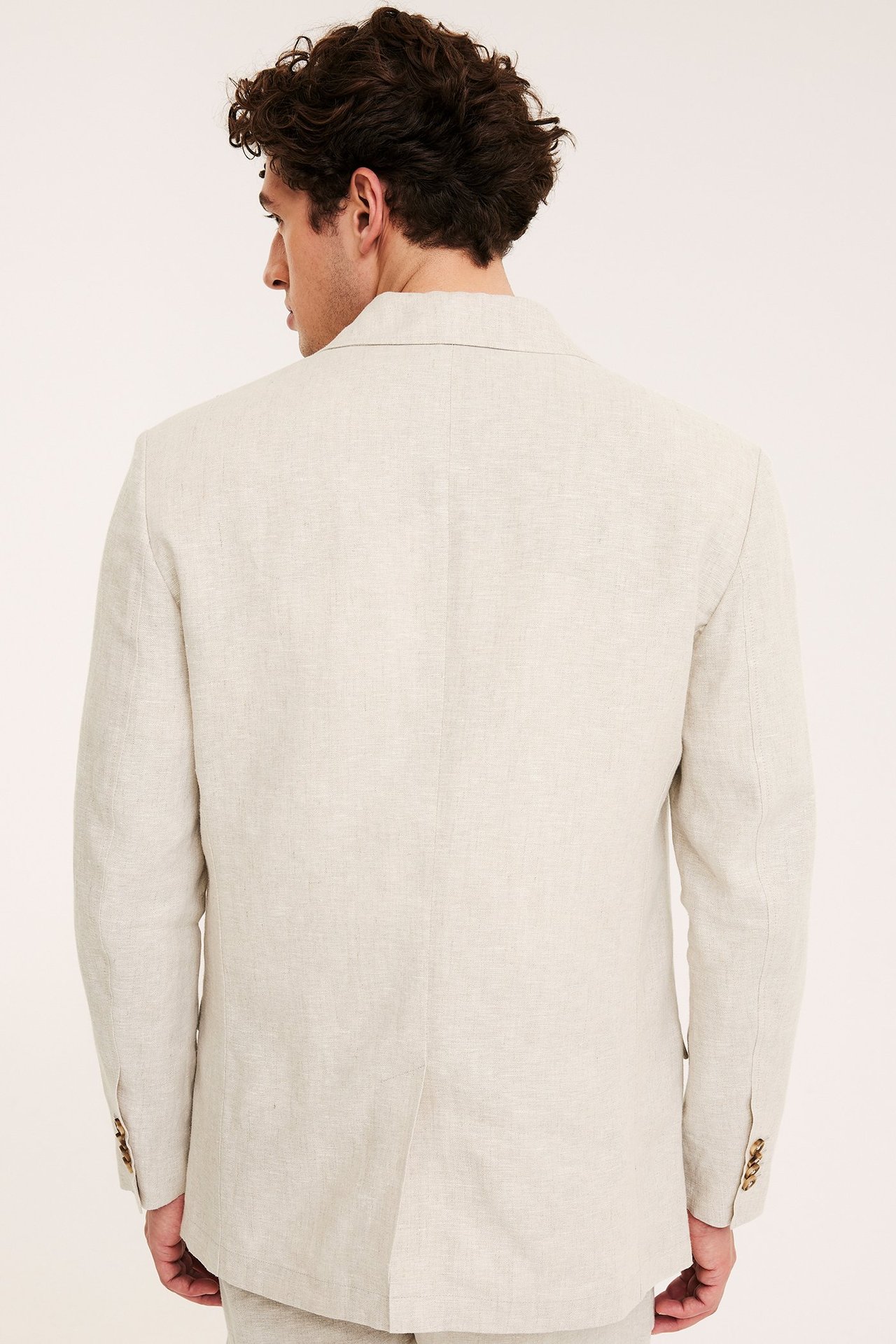 Bakfra: Mann i en beige regular fit linnekavaj med ermeknapper.