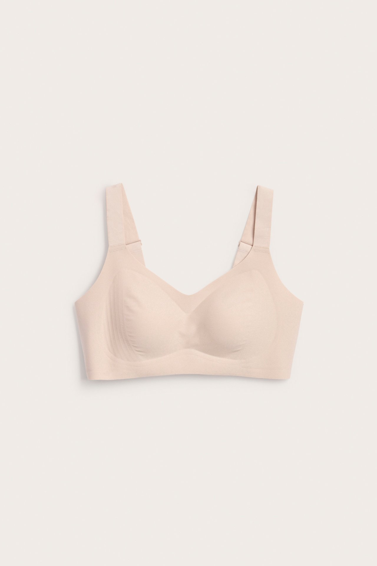 Vaaleanpunainen langaton mikroliivit edestä, säädettävillä olkaimilla ja sileillä saumattomilla kupeilla.