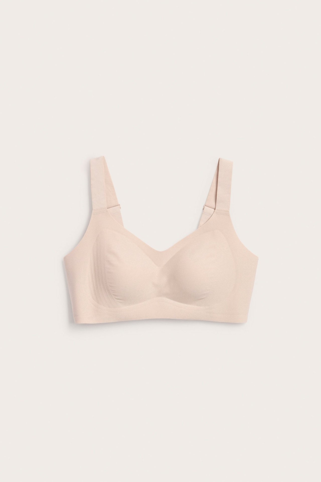 Vaaleanpunainen langaton mikroliivit edestä, säädettävillä olkaimilla ja sileillä saumattomilla kupeilla.