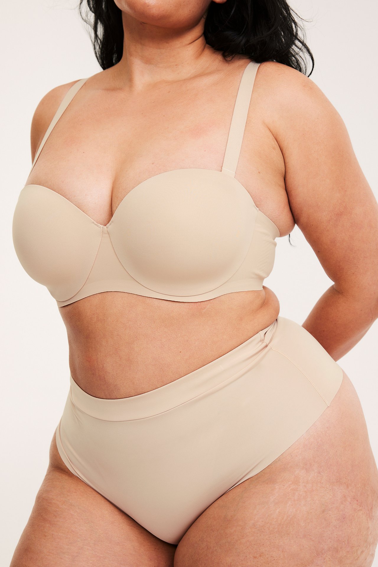 Från framsidan: En kvinna i en ljusrosa sömlös micro stringtrosa och matchande behå.