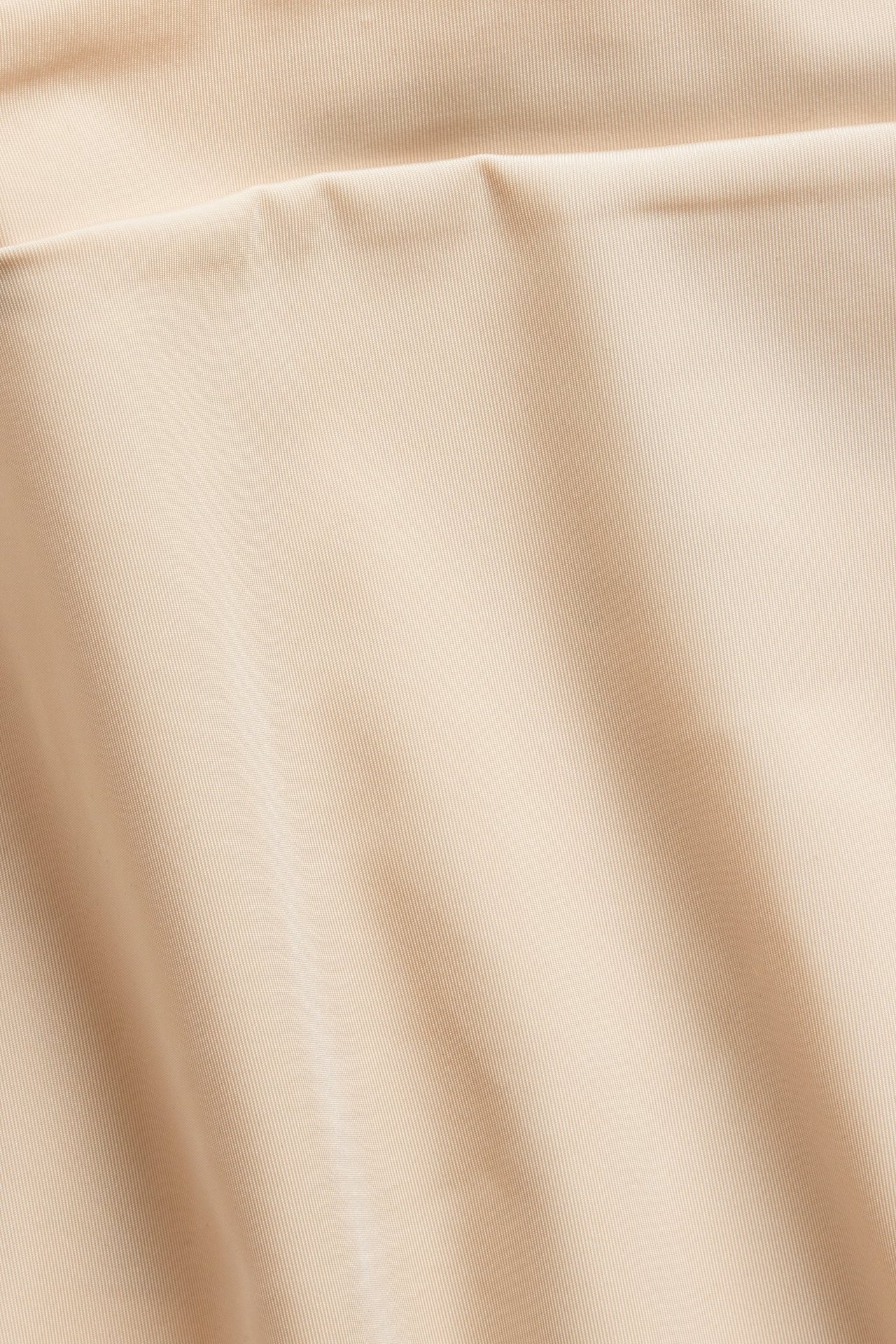 Nærbilde av en lys rosa, ensfarget mikrofiberstring med sømløs design.