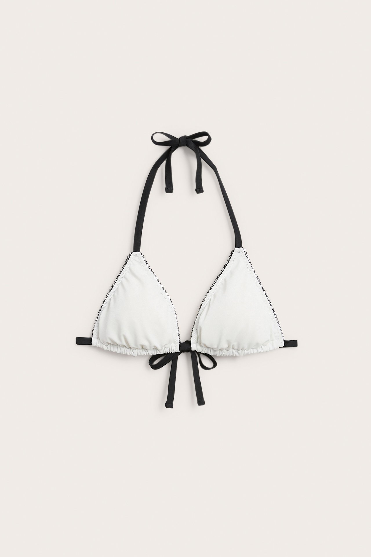Z przodu: kremowy, wyściełany biustonosz bikini trójkątny z czarnymi detalami picot i wiązaniami.