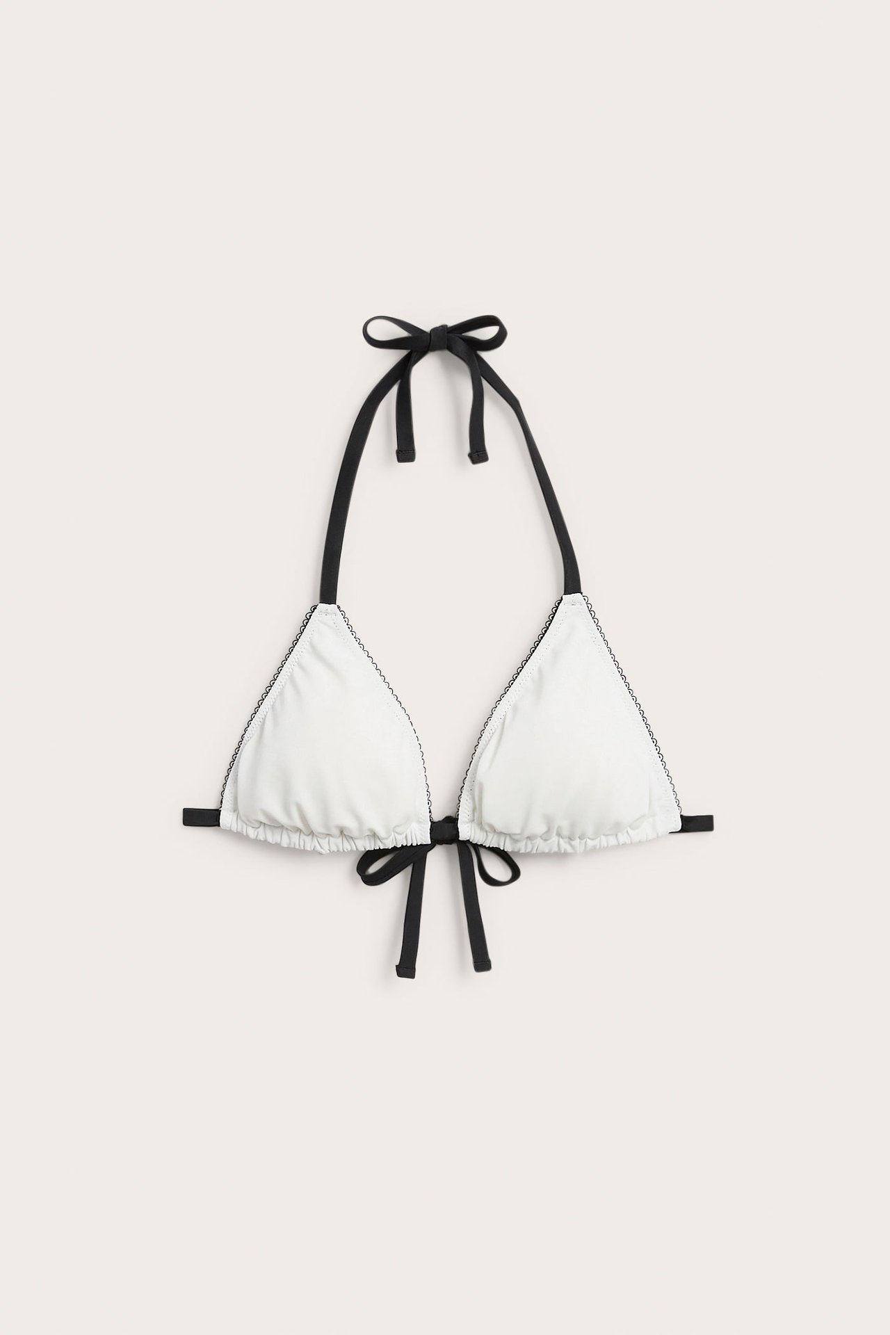Z przodu: kremowy, wyściełany biustonosz bikini trójkątny z czarnymi detalami picot i wiązaniami.