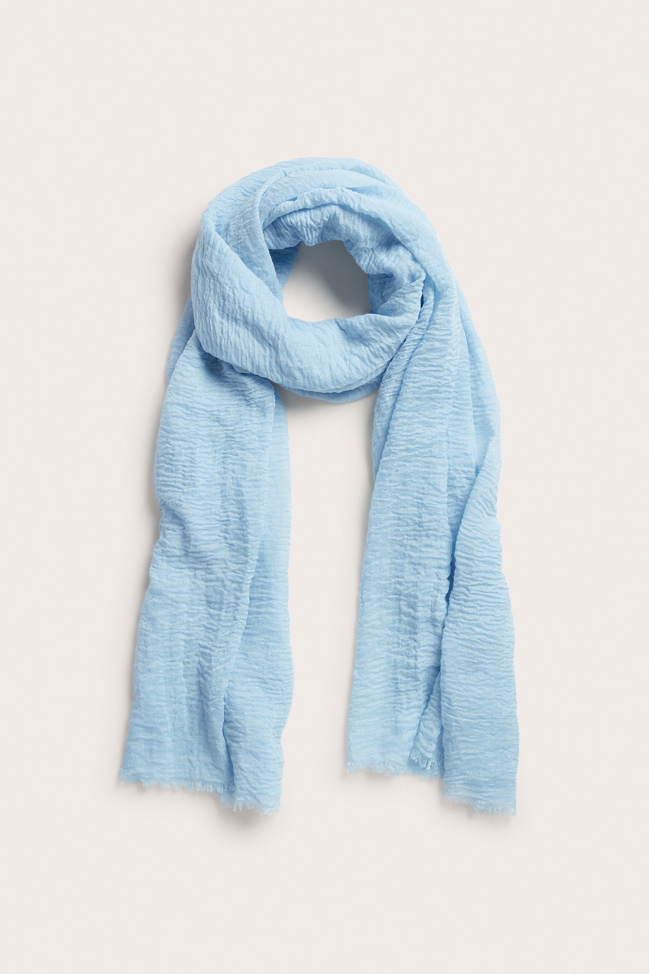 Edestä näkymä vaaleansinisestä ryppyisestä polyesterihuivista, aseteltuna.